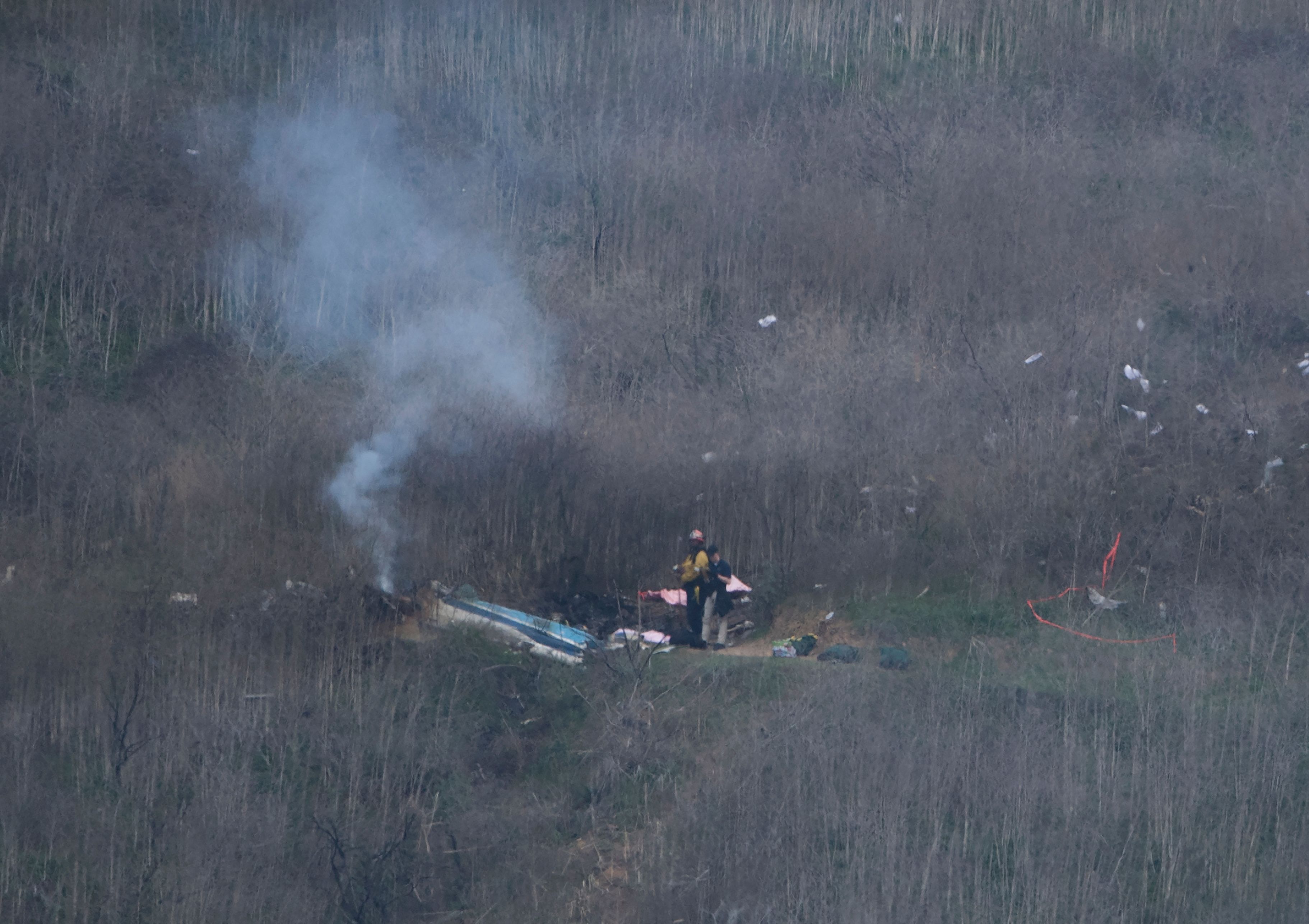 Petugas berada di lokasi kecelakan helikopter yang menewaskan bintang NBA Kobe Bryant, 26 Januari 2020.