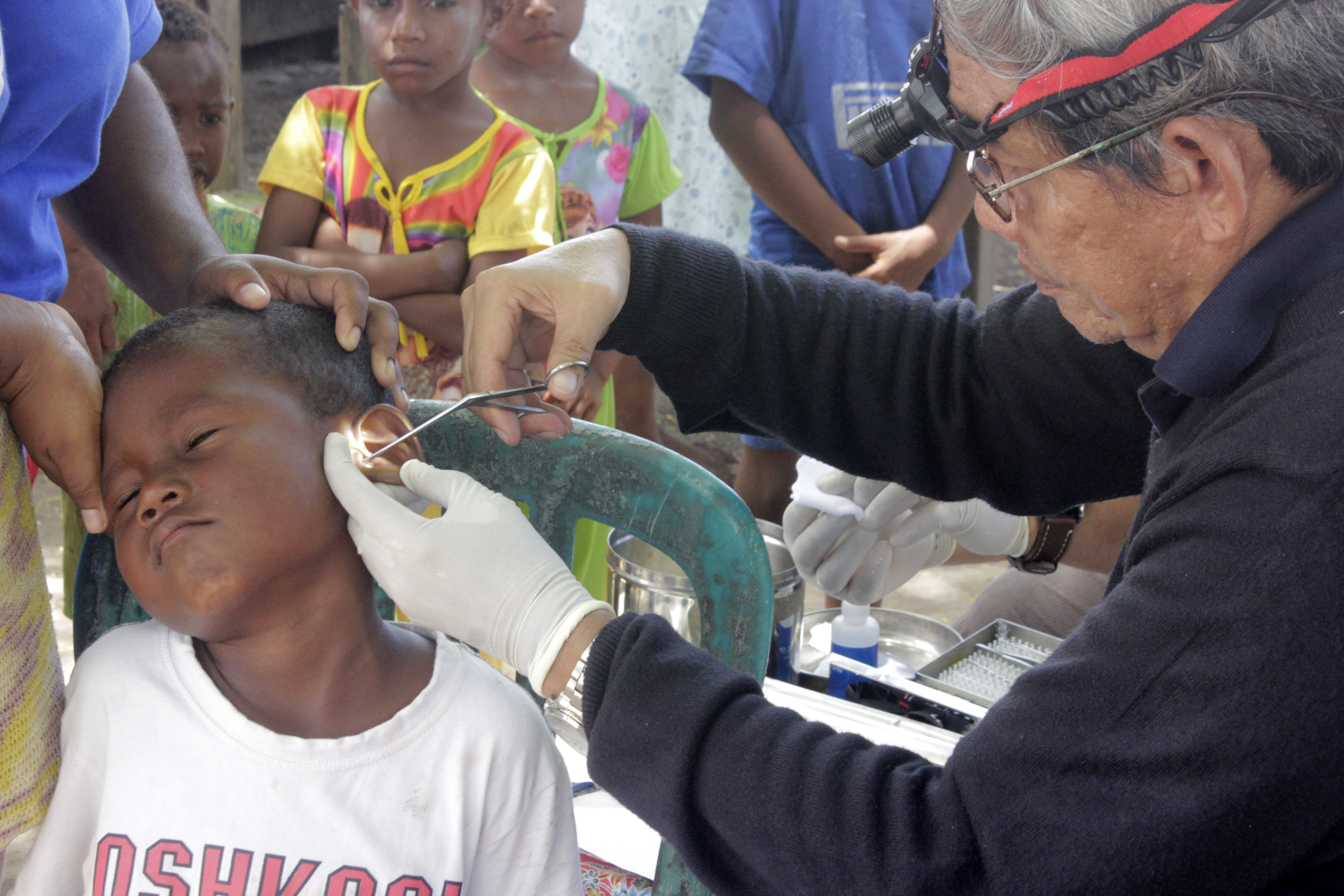 Dokter spesialis THT saat memeriksa telinga seorang anak di wilayah Papua.