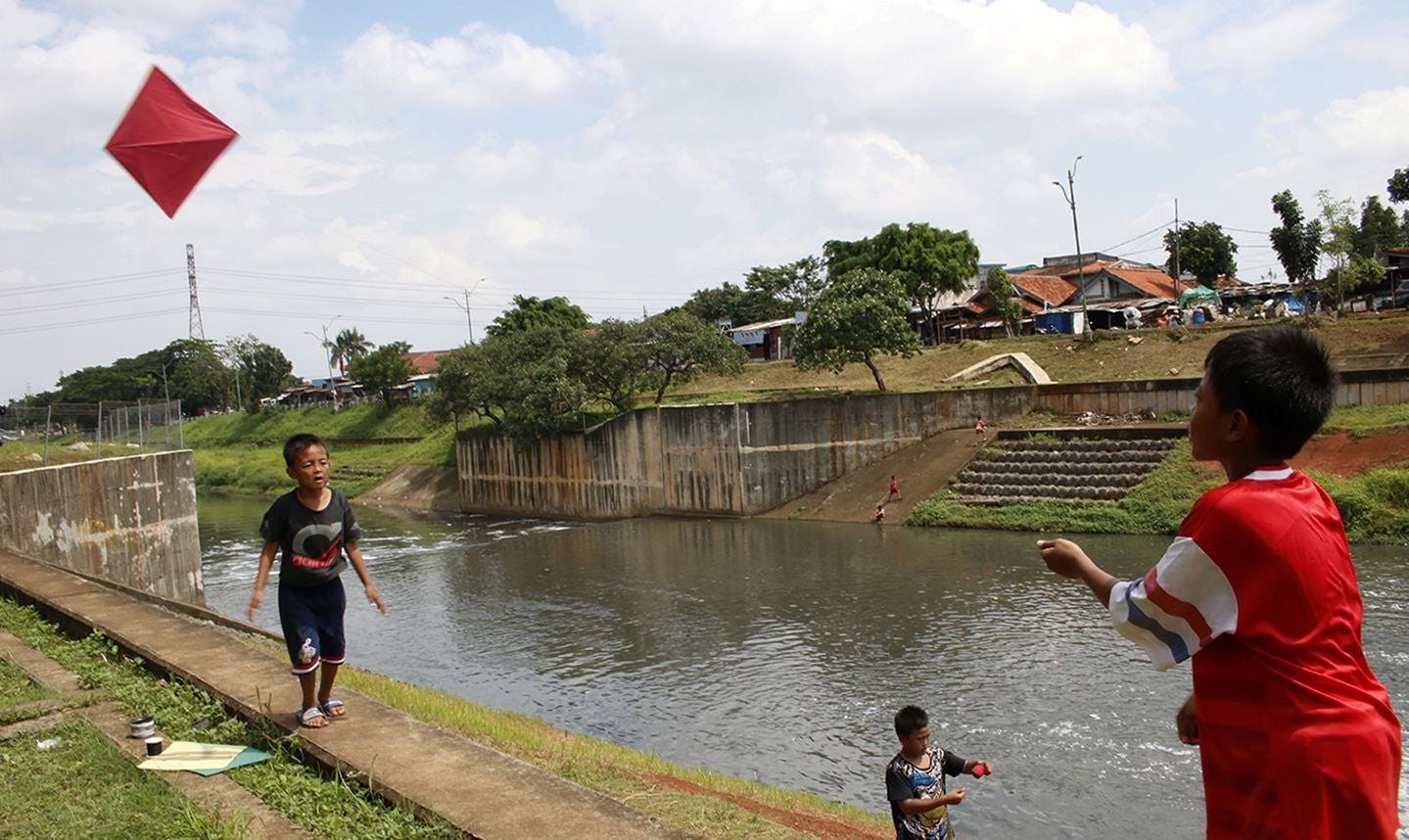 Anak-anak bermain layangan di Banjir Kanal Timur (BKT), Jakarta Timur.