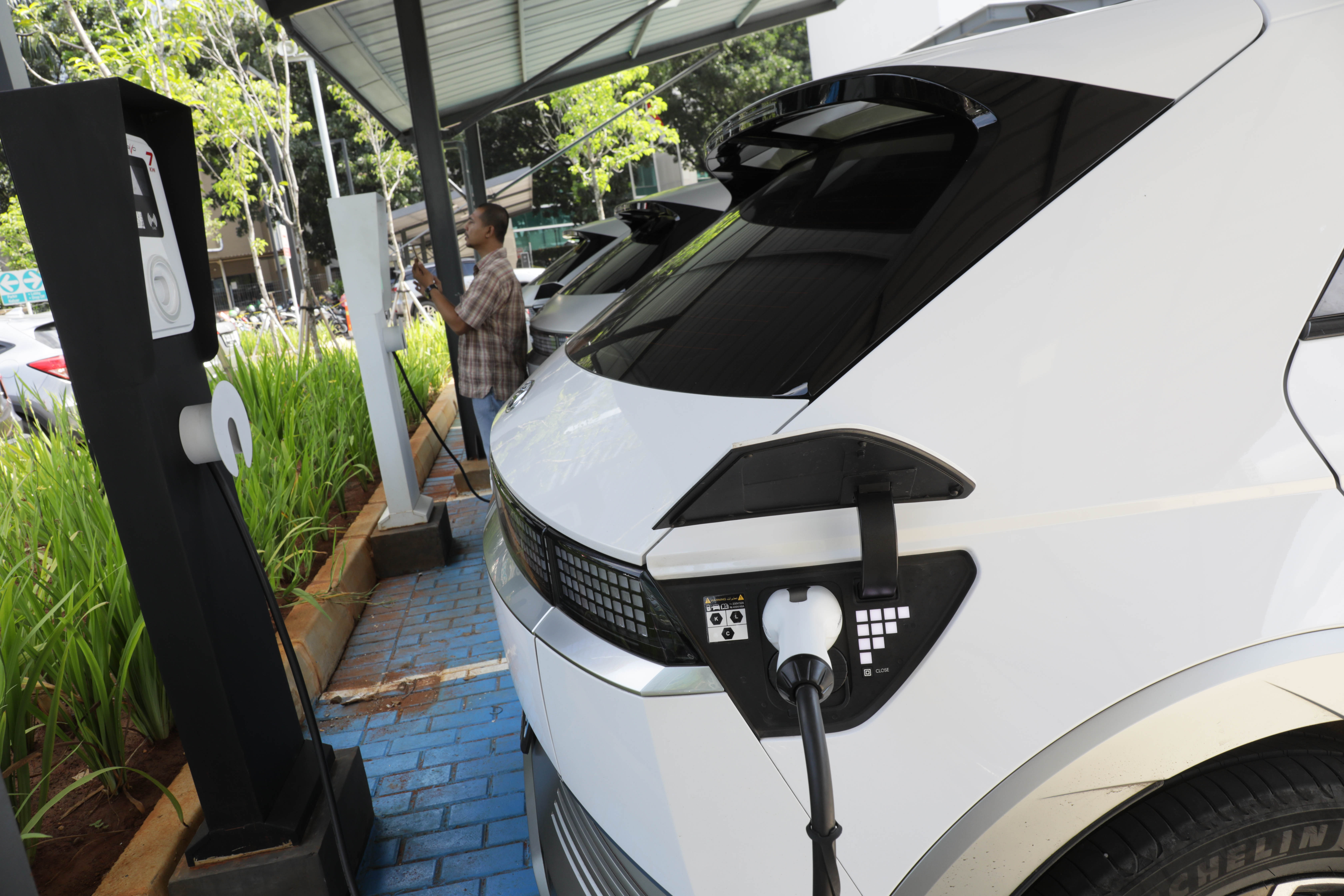 Ilustrasi mobil listrik mengisi baterai