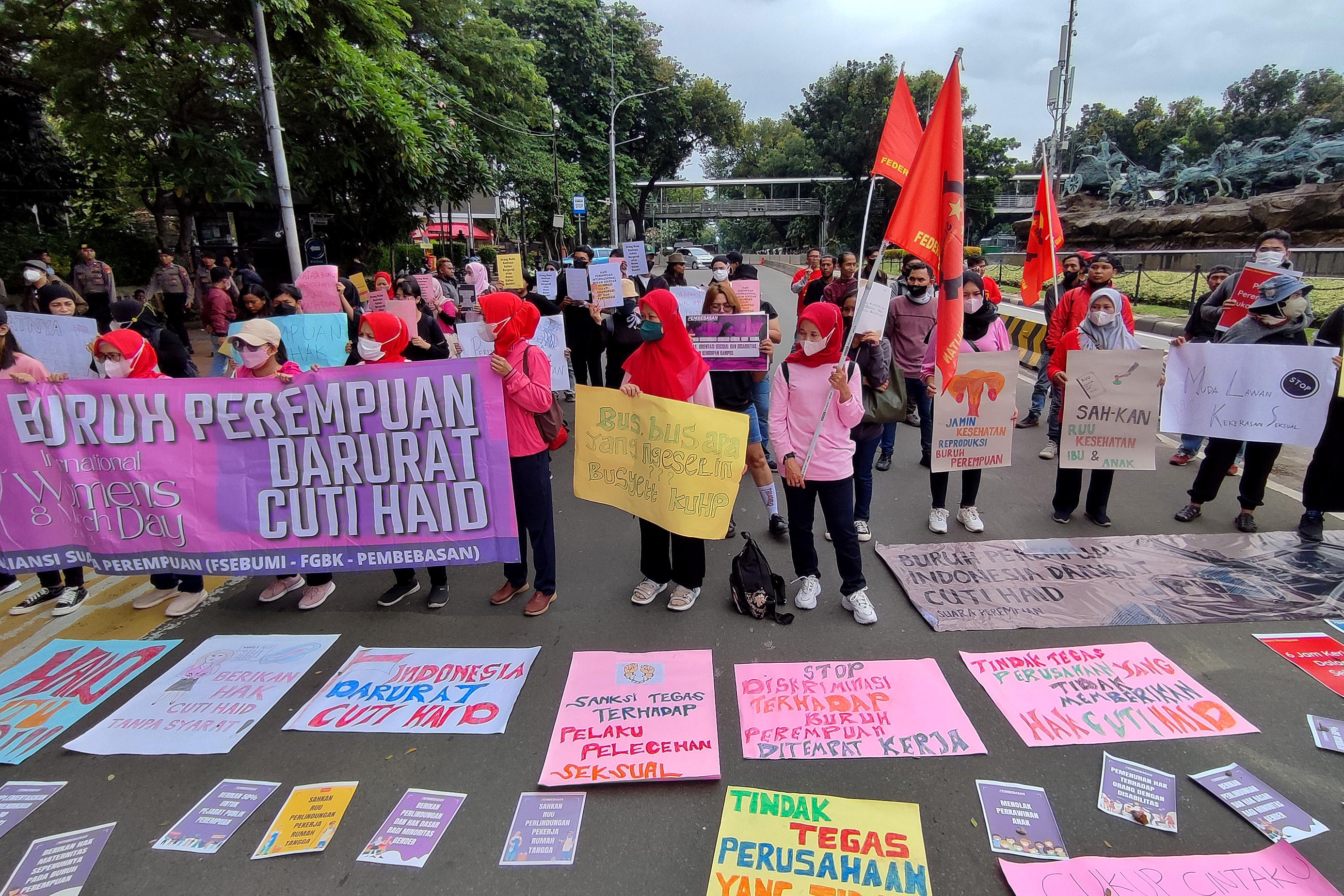 Aktivis dari Aliansi Perempuan Menggugat melakukan aksi damai dengan membentangkan poster di kawasan Patung Kuda, Jakarta, Rabu (8/3/2023). 
