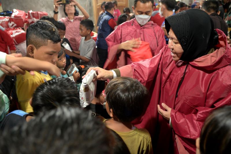 Menteri Soisal Tri Rismaharini menyerahkan bingkisan kepada anak-anak di lokasi terdampak banjir dan tanah longsor di Manado.