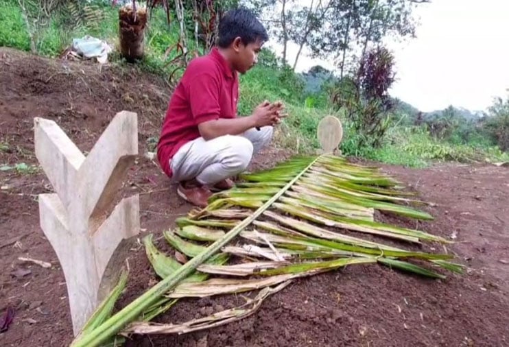 Juju Junaedi berdoa di makam istrinya, Kurnaesih, yang meninggal bersama bayi yang dikandungnya karena ditolak melahirkan di RSUD Ciereng.