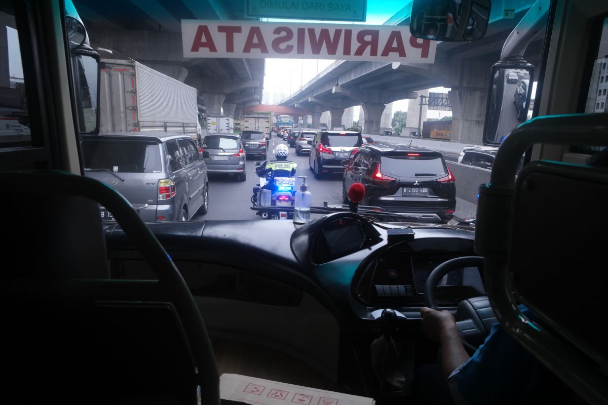 Petugas Patwal mengawal bus menembus kemacetan di jalan Tol Cikampek, Jakarta.