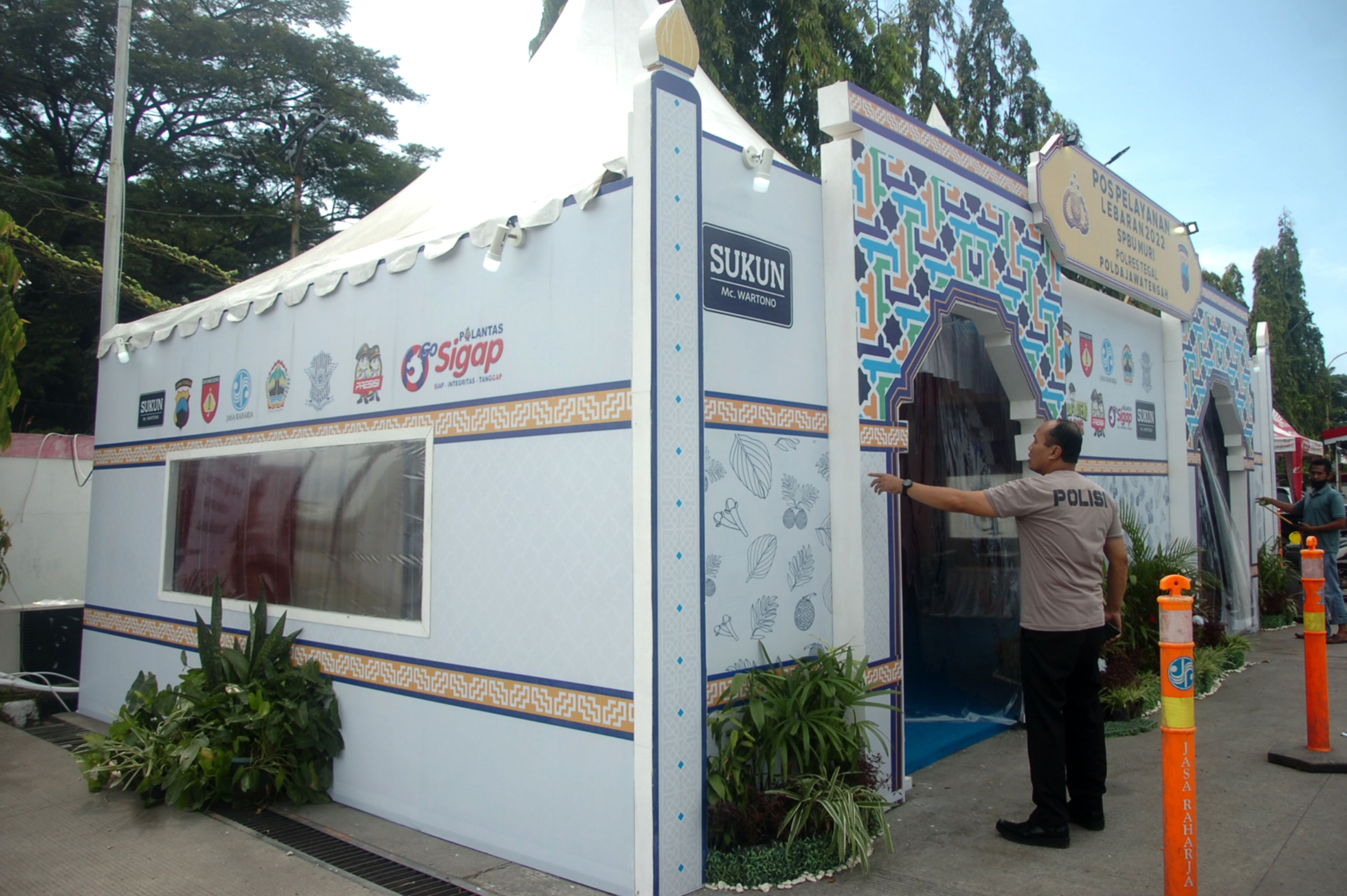 Anggota polisi dibantu pekerja menyelesaikan pembangunan pos pelayanan Operasi Ketupat Candi 2022. 