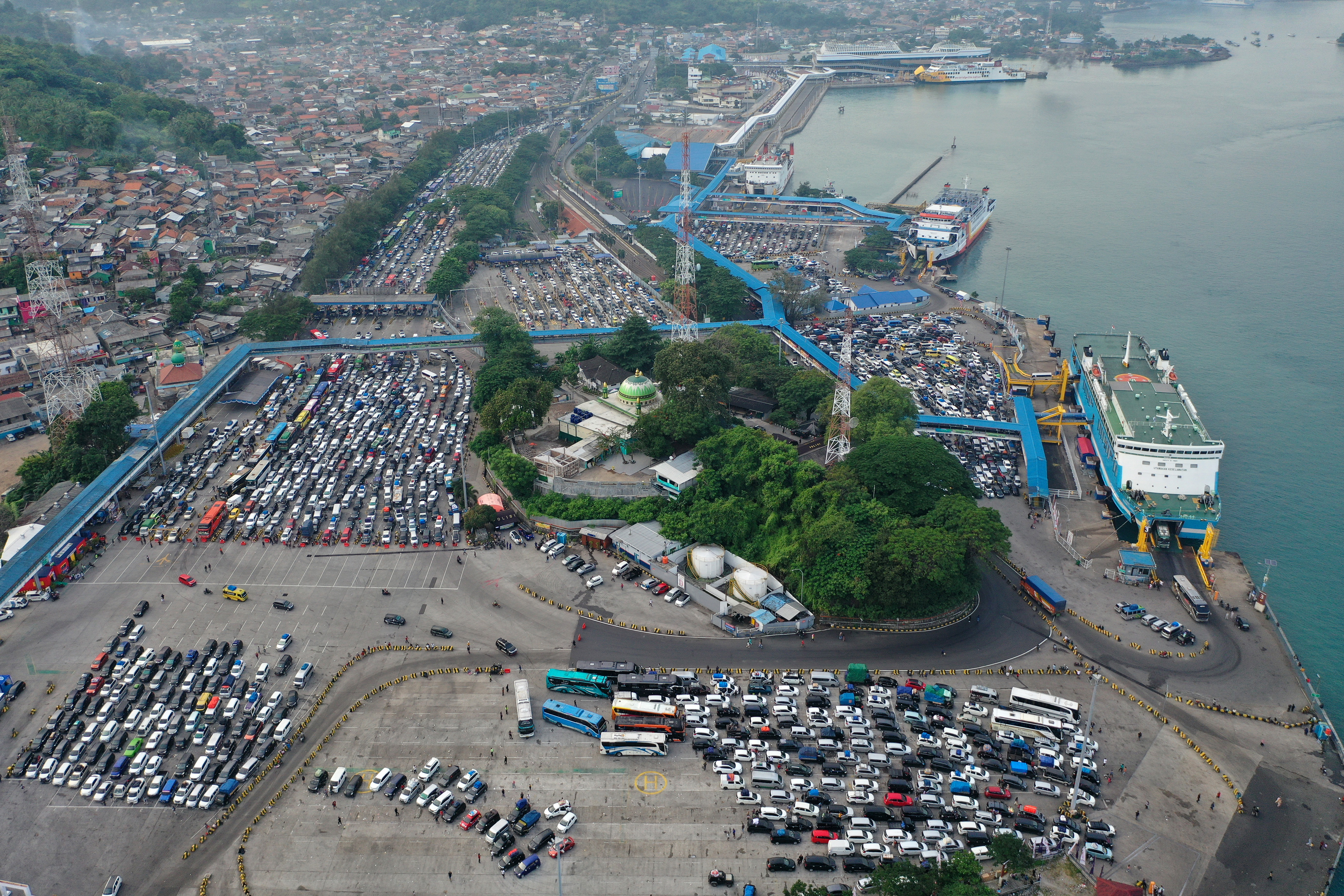 Foto udara sejumlah mobil pribadi dan bus berisi pemudik antre menaiki kapal di Pelabuhan Merak, Banten