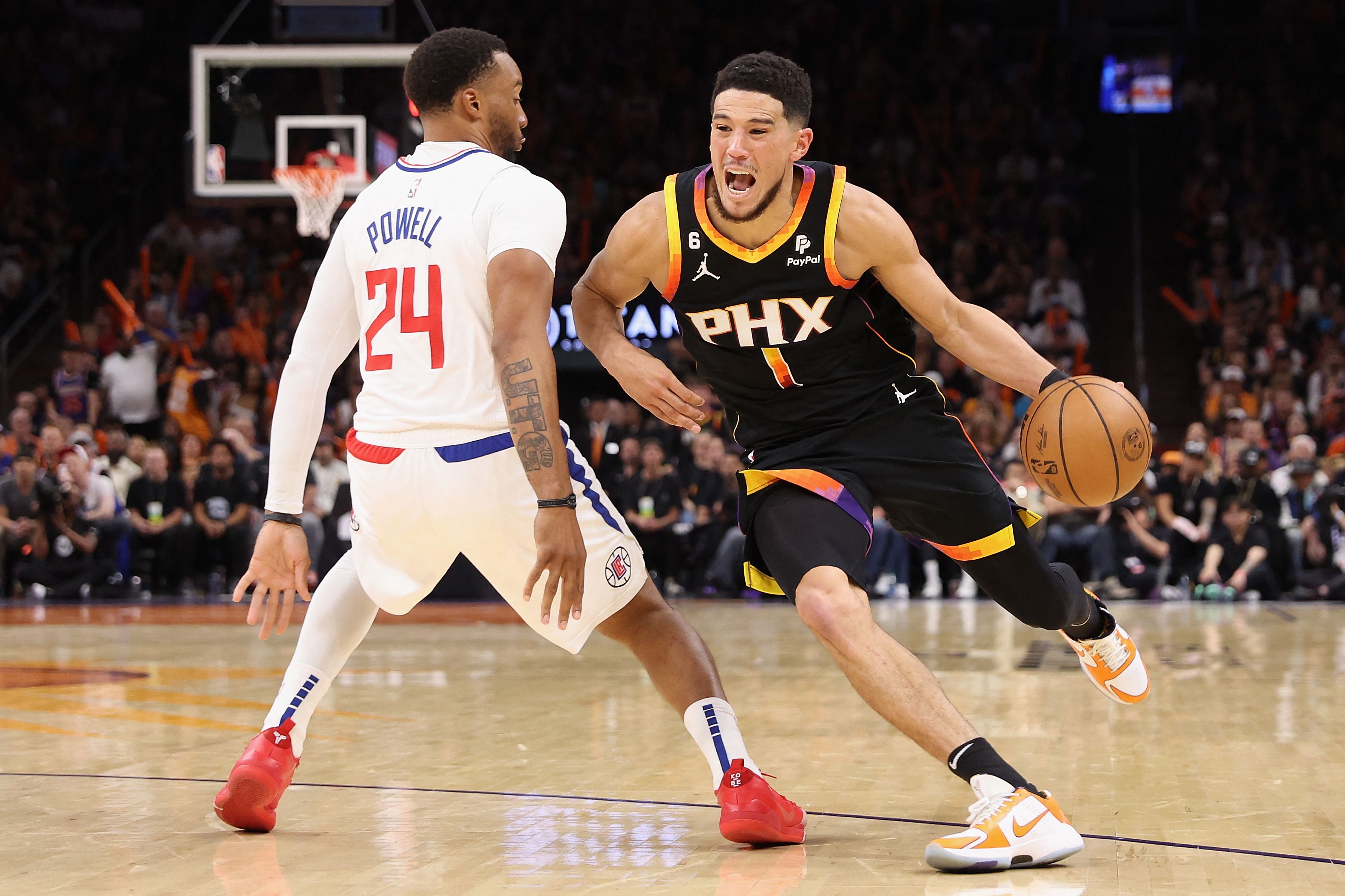 Pebasket Phoenix Suns Devin Booker berusaha melewati hadangan pemain Los Angeles Clippers di laga playoff NBA.