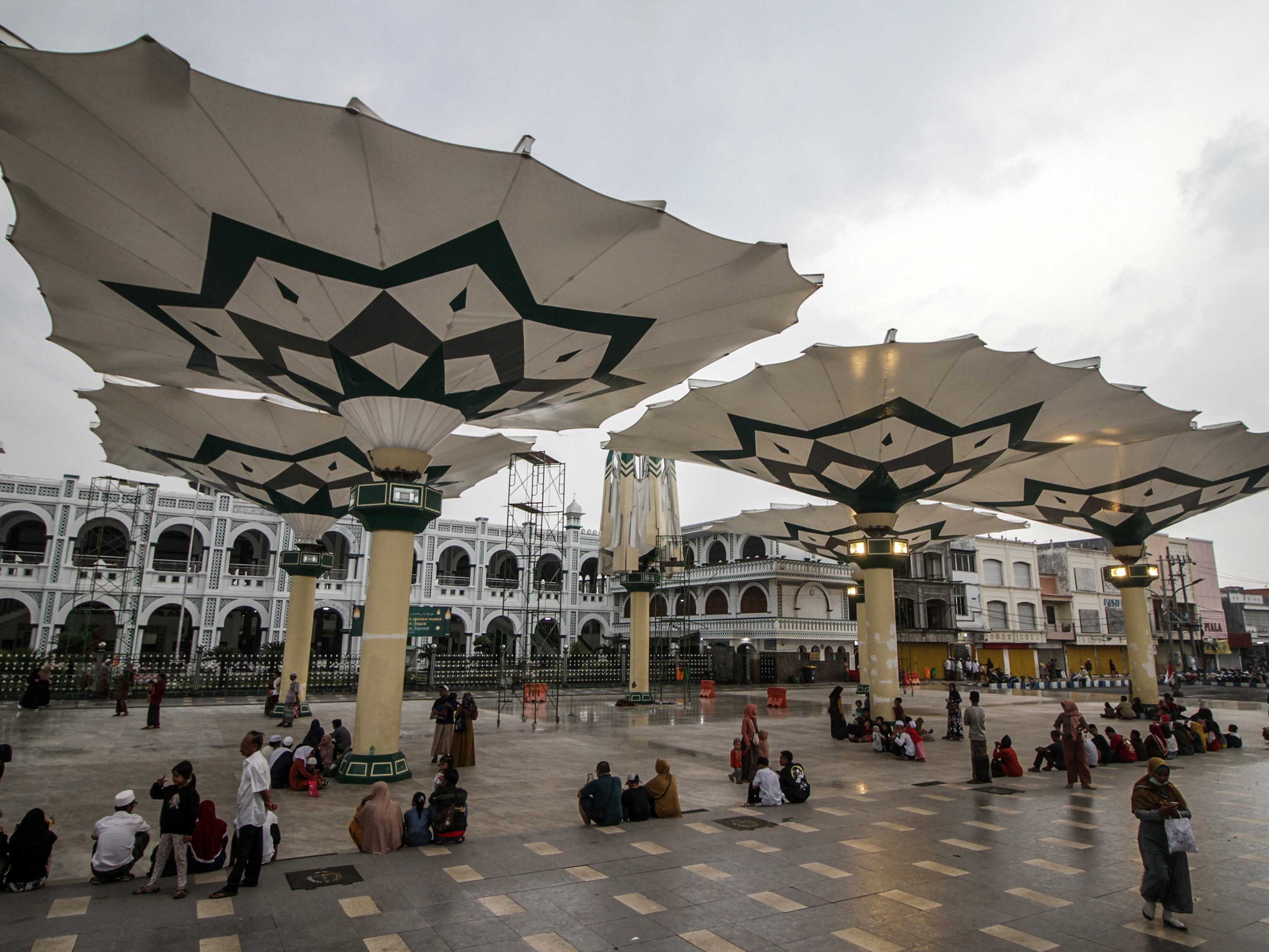 Sejumlah warga mengunjungi wisata payung Madinah di depan Masjid Agung Al-Anwar di kawasan Alun-alun Kota Pasuruan, Jatim, Kamis (23/3).