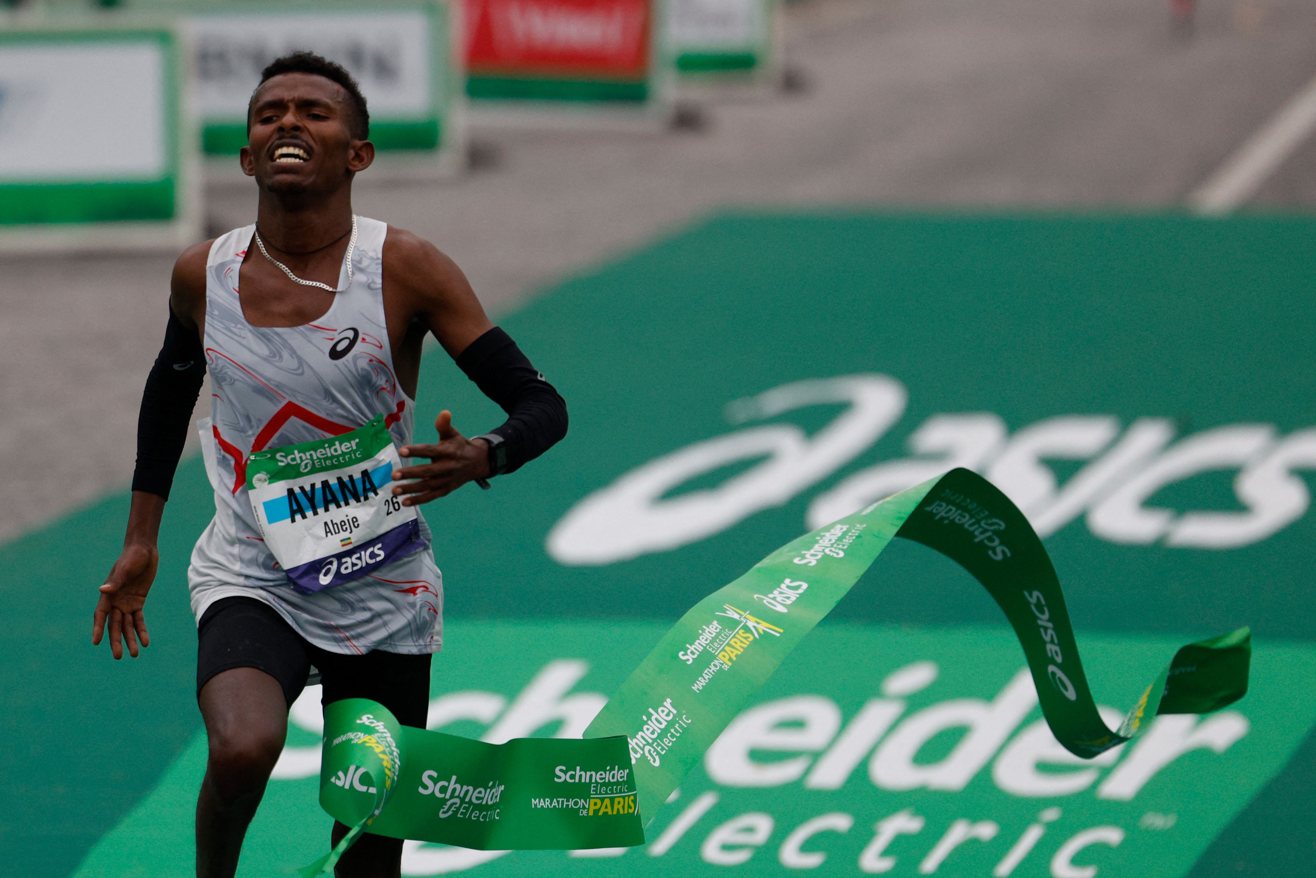 Pelari Ethiopia Abeje Ayana menyentuh finis pertama dalam kejuaraan Paris Marathon, Minggu (2/4)