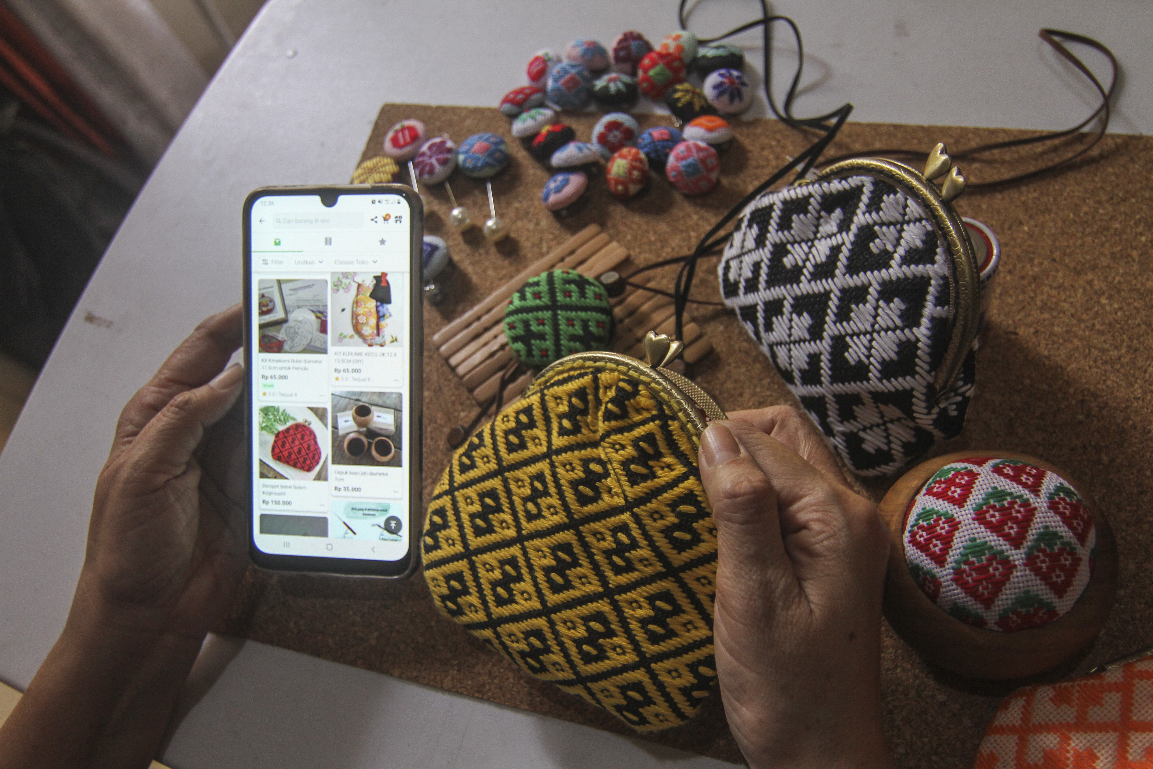  Perajin melihat stok kerajinan aksesori koginsashi miliknya pada aplikasi jual beli di Asriku Kreasi, Depok, Jawa Barat.