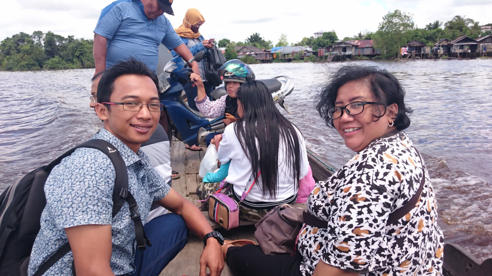 Sukarman (kiri) saat sedang menuju lokasi sekolah yabg ditempuh melalui jalur sungai. 