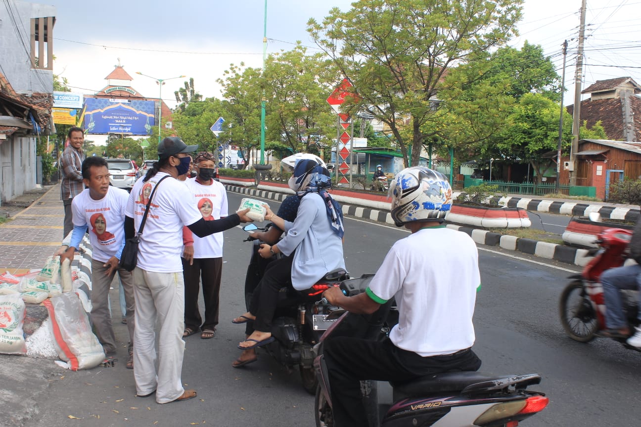  Relawan 'Sahabat Mbak Endah' (SME) dengan membagikan beras kepada warga di Demak, Jateng.