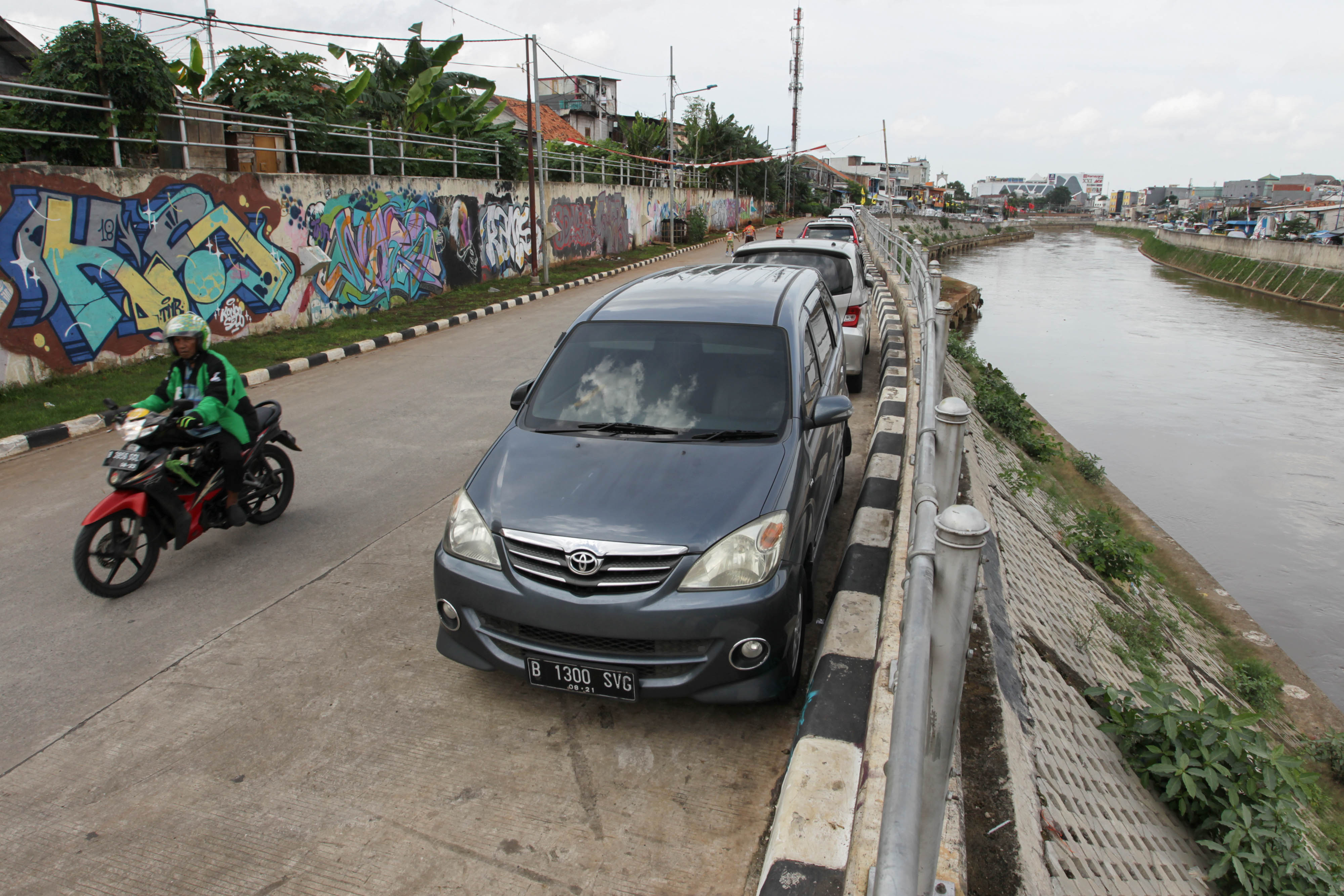 Sejumlah kendaraan terparkir di Jalan Bukit Duri Tanjakan, Jakarta, Kamis (24/1). Pemilik kendaraan tidak memiliki garasi tempat parkir