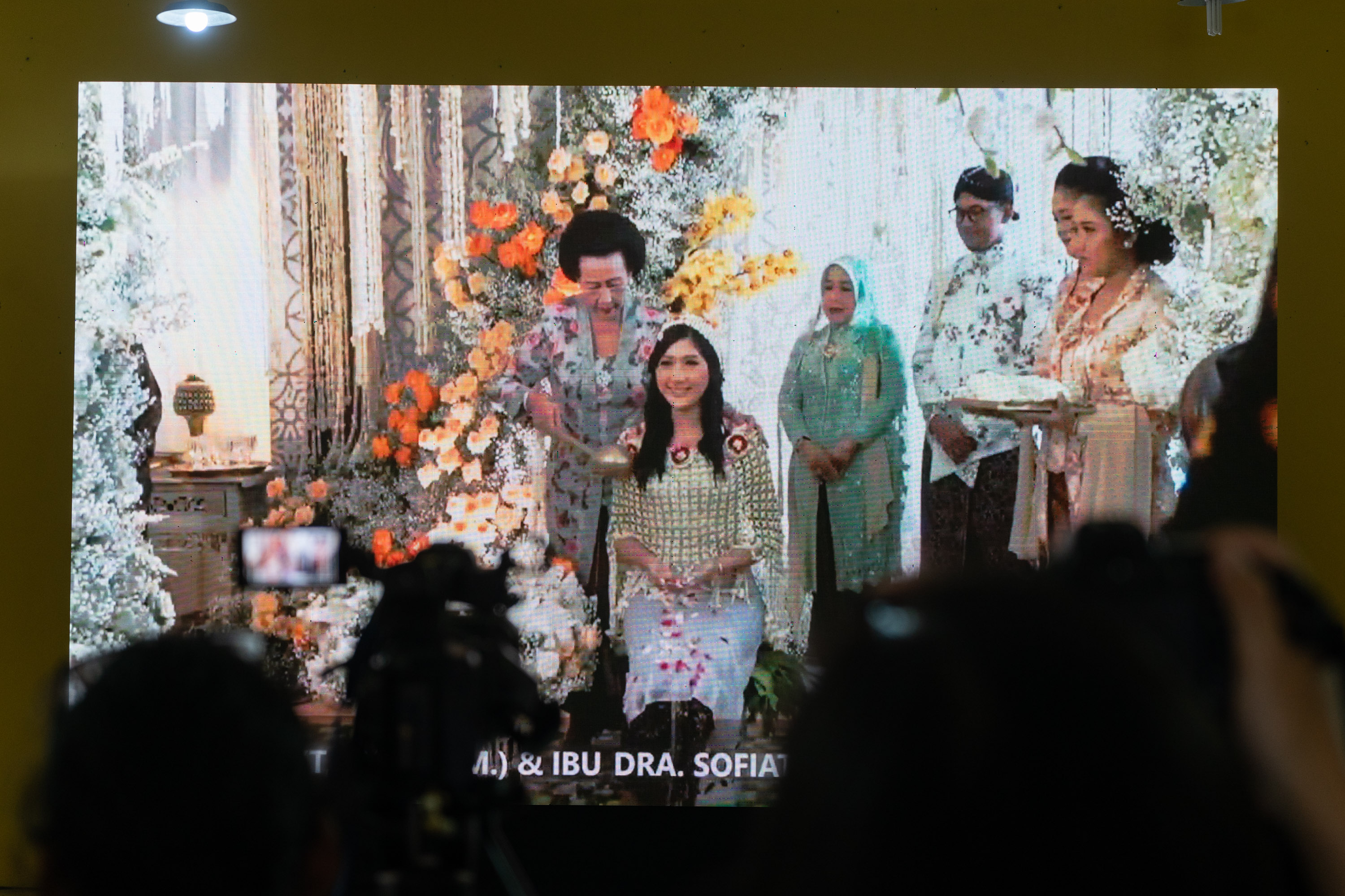 Warga menyaksikan tradisi siraman Erina Gudono melalui layar di gedung serbaguna Purwosari, Sinduadi, Mlati, Sleman, D.I Yogyakarta