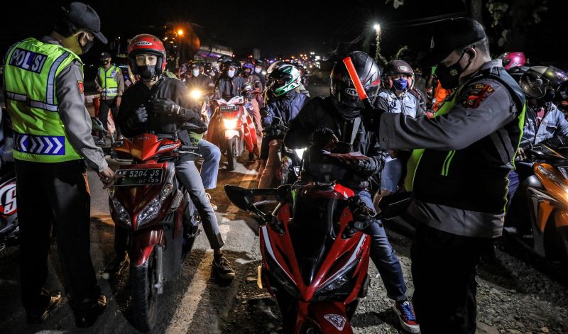  Petugas kepolisian melakukan pemeriksaan kepada pemudik sepeda motor.