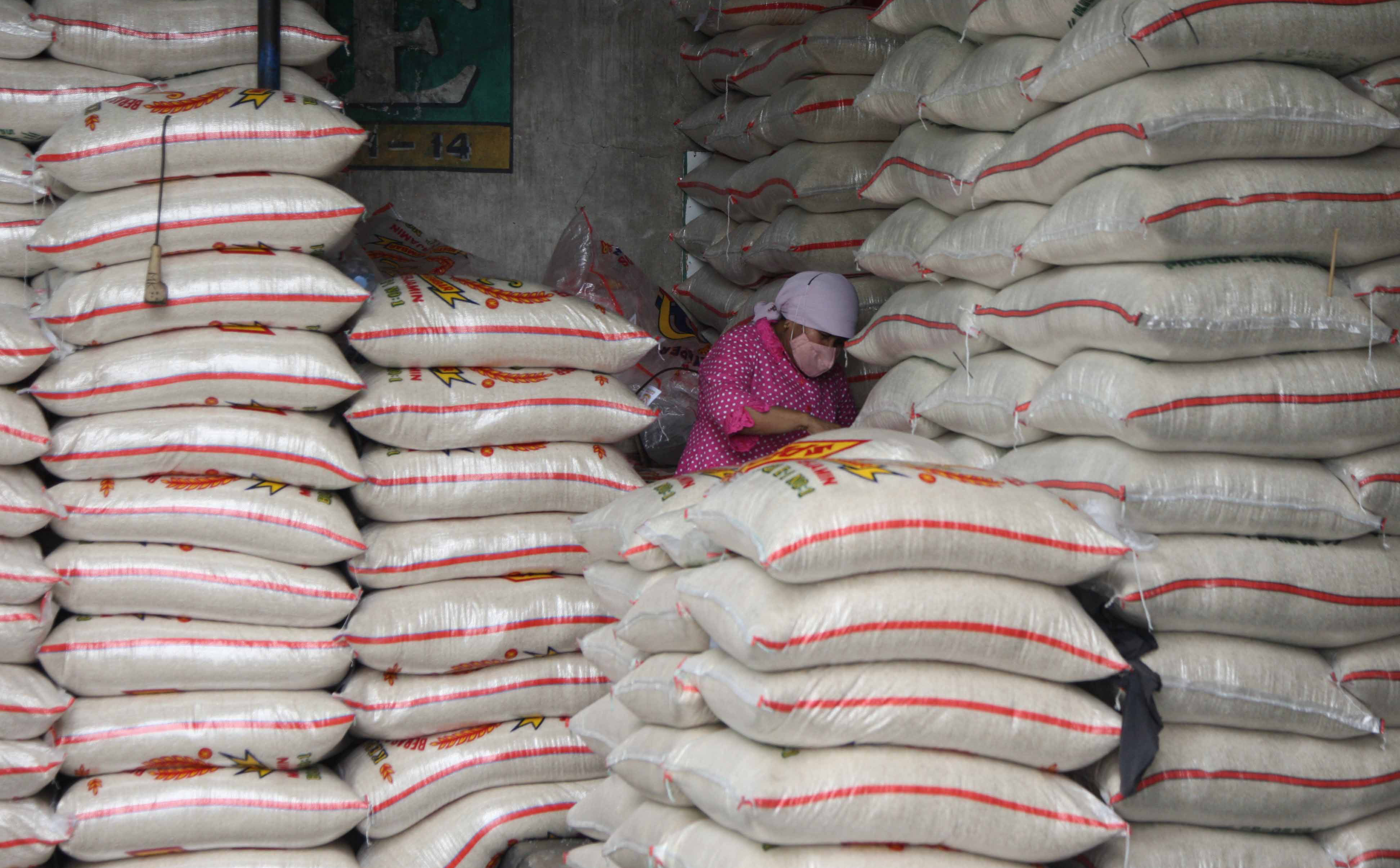 Pedagang beras tengah memeriksa dagangannya di Pasar Induk Beras Cipinang, Jakarta Timur.