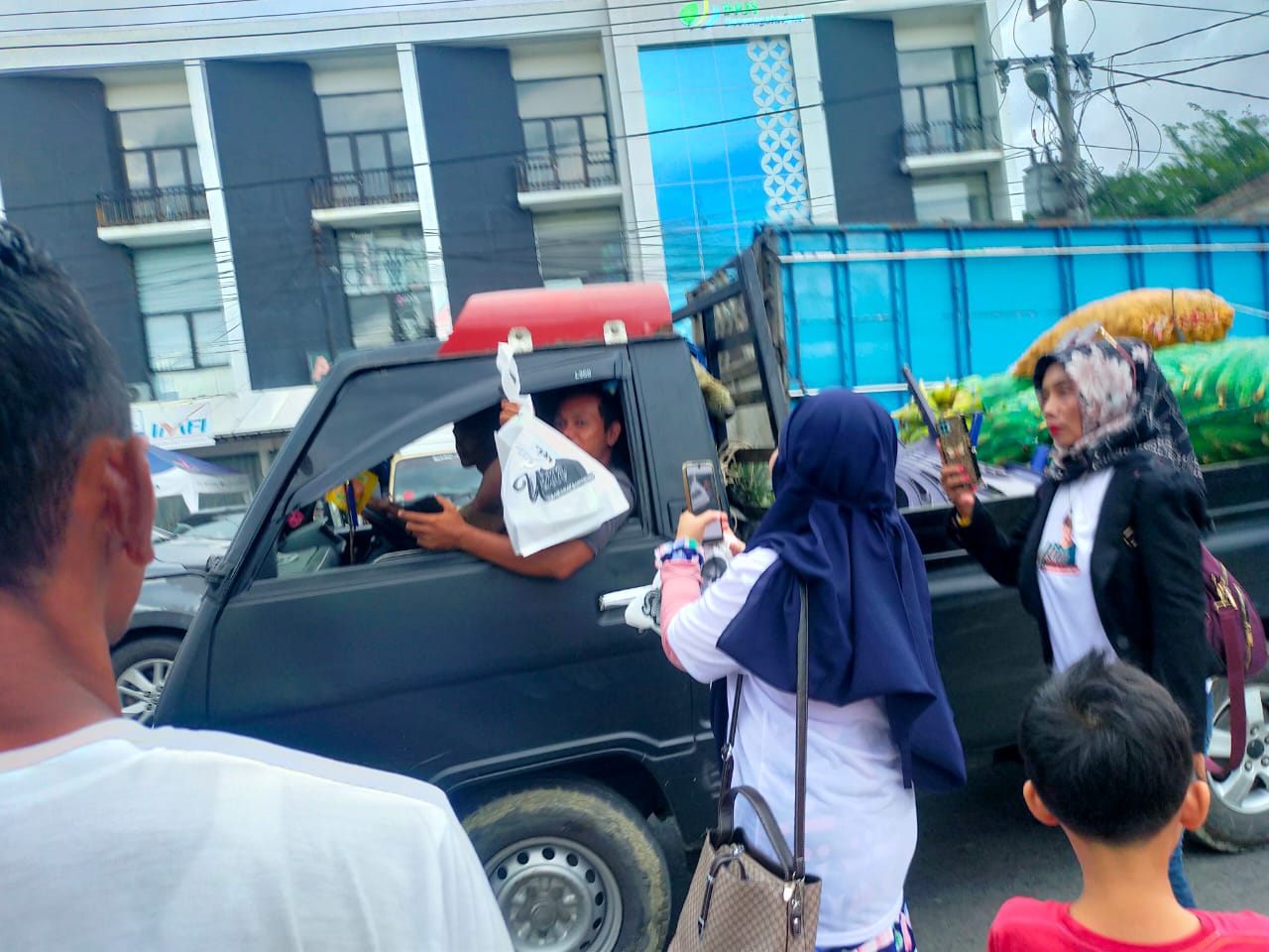 Relawan Sandi membagikan kuliner yang dibeli dari UMKM kepada masyarakat di sekitar pasar Pringsewu, Lampung, Senin (3/4) sore.  