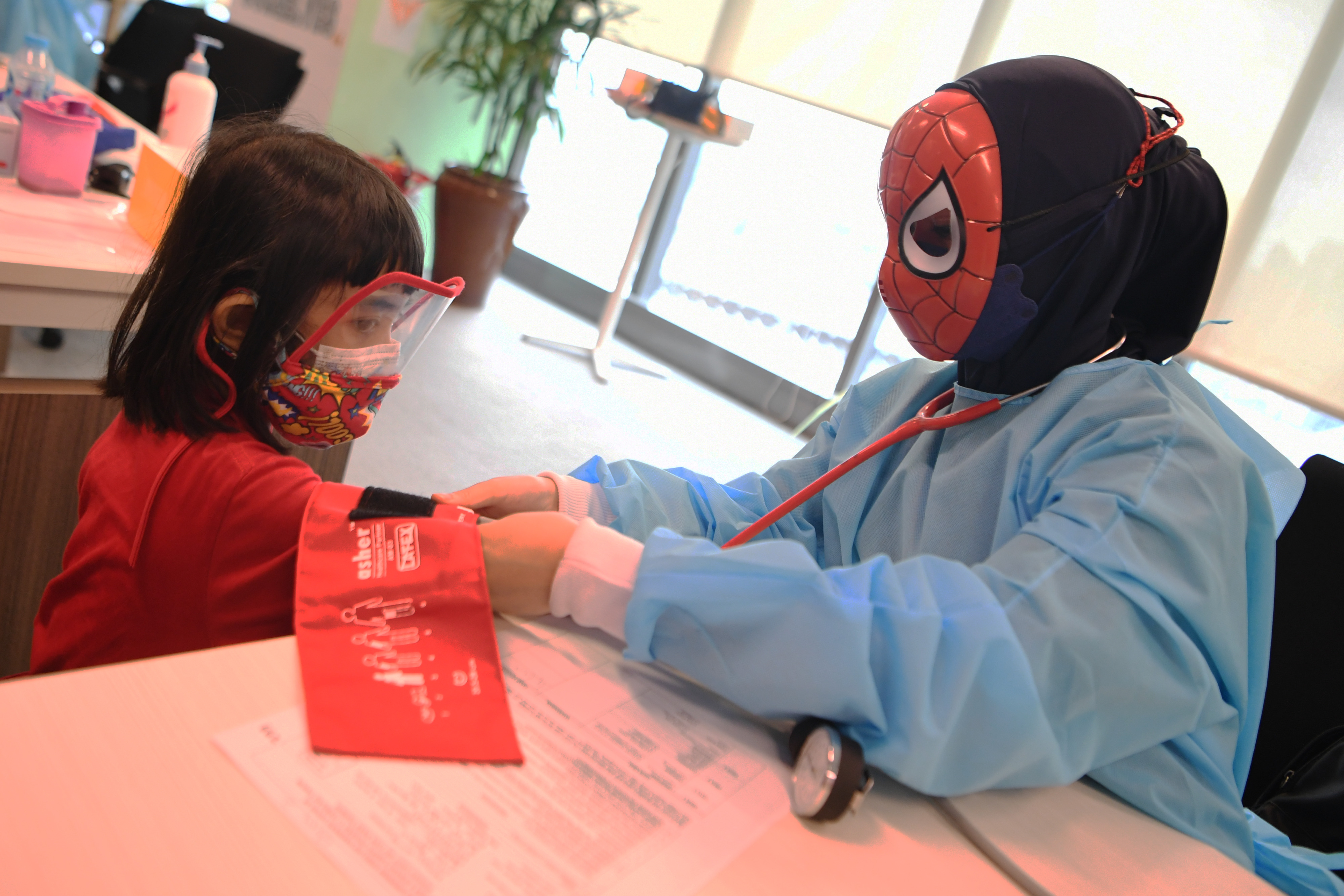 Seorang nakes memeriksa tekanan darah anak.