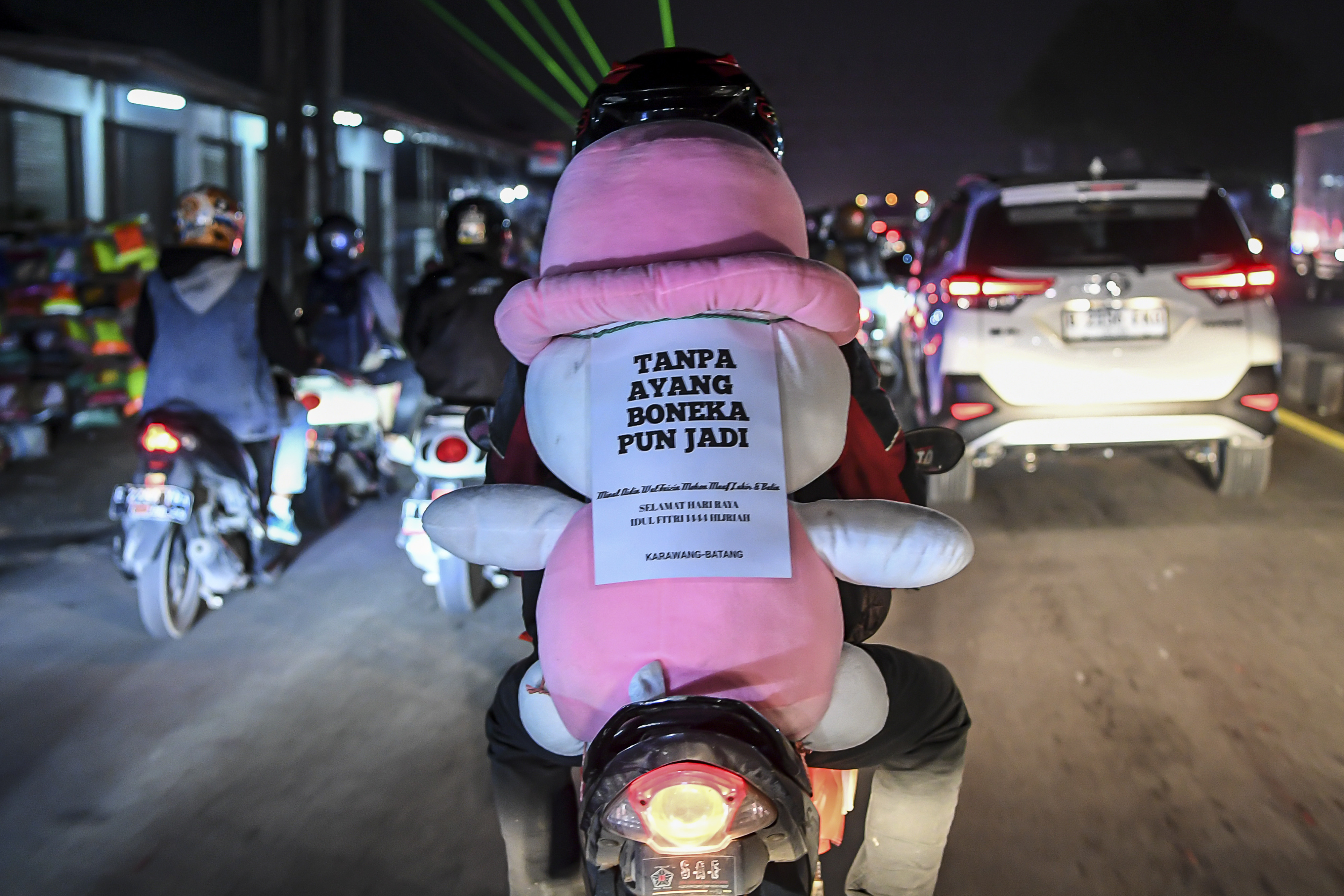  Pemudik bersepeda motor membonceng boneka saat melintas di jalur Pantura
