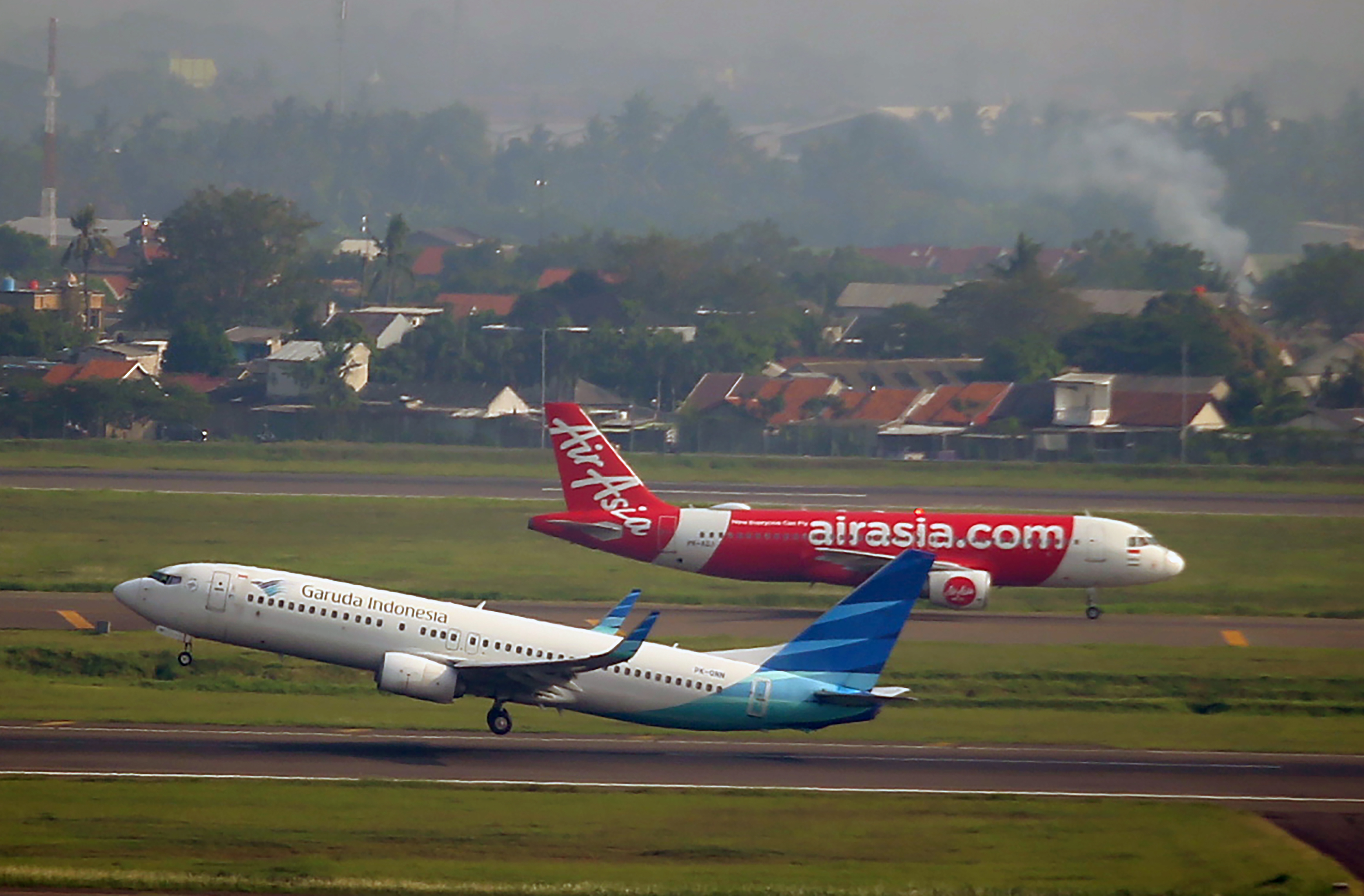 Dua pesawat siap lepas landas dan mendarat di runway.