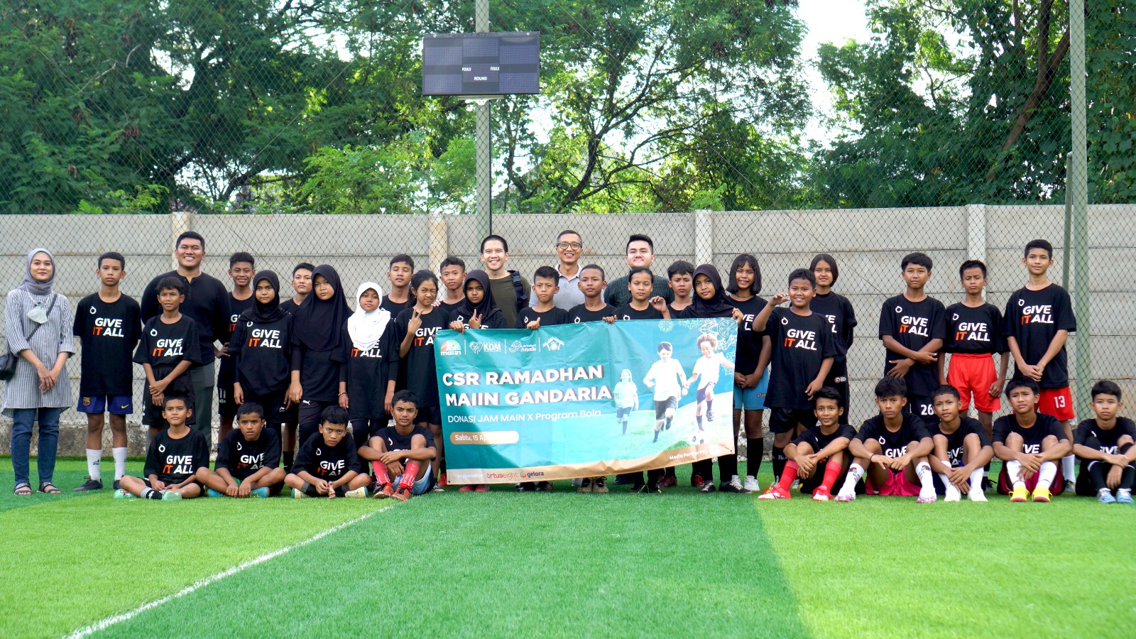 Direktur PT Triyasa Propertindo Andrie Gotama (tengah, berkacamata & kaus abu-abu) berfoto bersama anak-anak penerima donasi Program Bola.