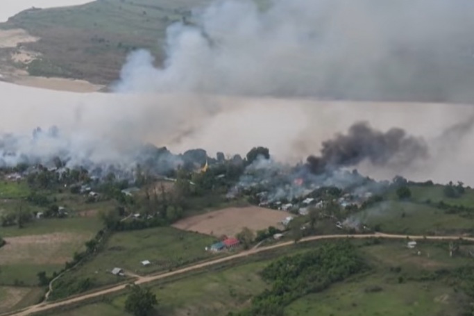 Asap mengepul dari permukiman di sepanjang Sungai Chindwin di wilayah Sagaing, Myanmar. 