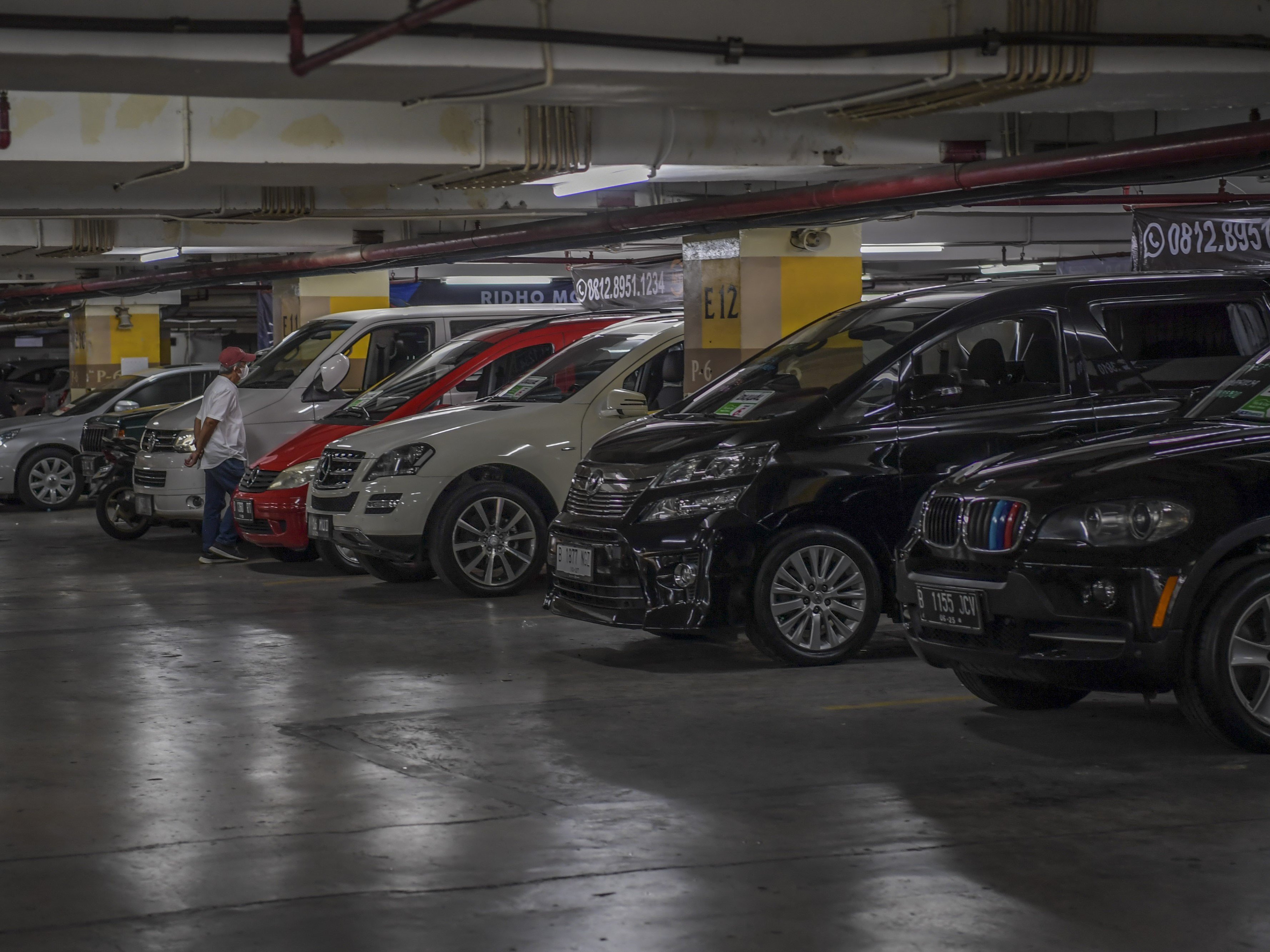 Calon pembeli melihat kondisi mobil bekas di ruang pamer penjualan mobil bekas, Gedung Parkir Blok M Square, Jakarta, Jumat (14/4/2023).