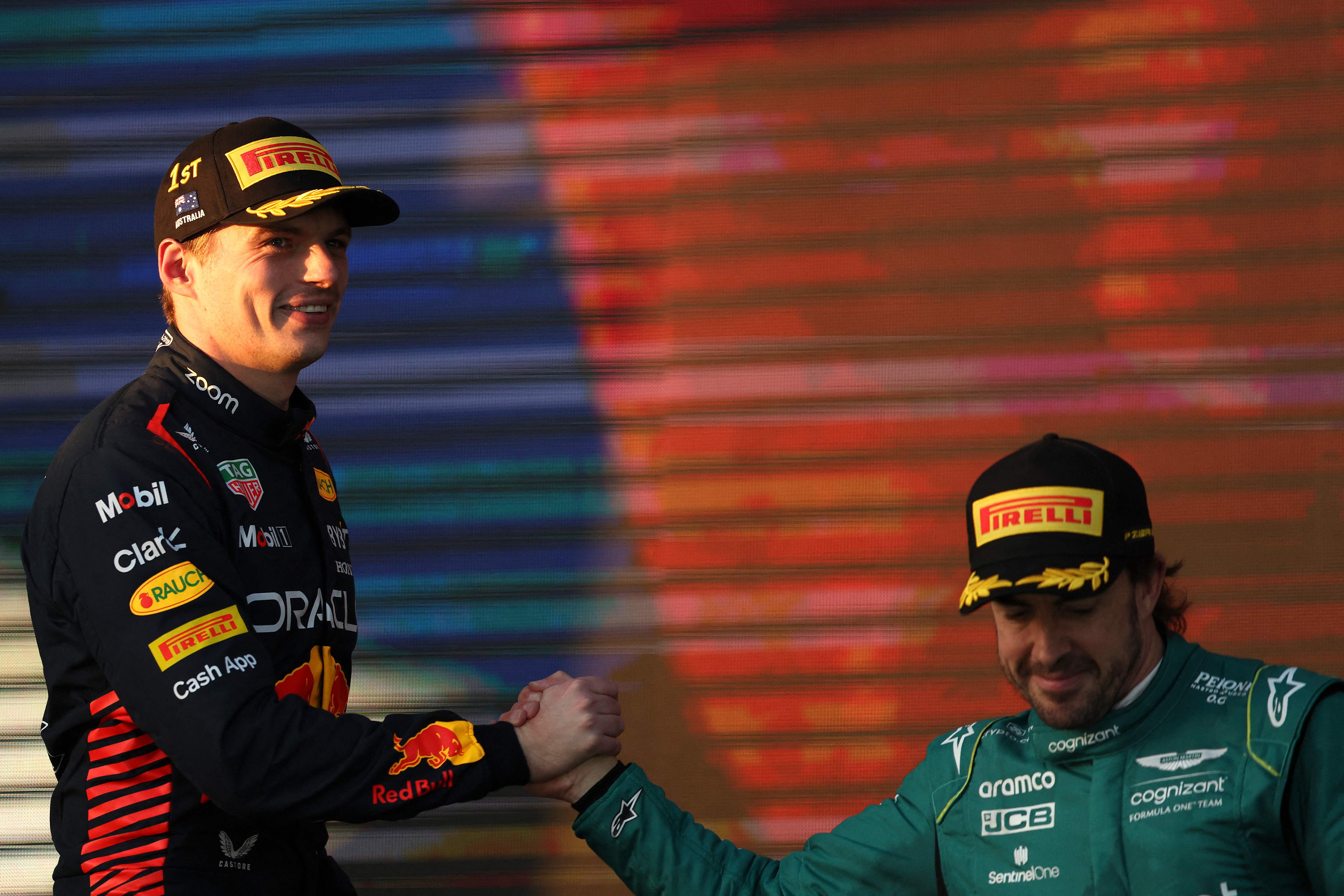 Pembalap Red Bull Max Verstappen (kiri) berjabat tangan dengan pembalap Aston Martin Fernando Alonso di podium GP Australia.