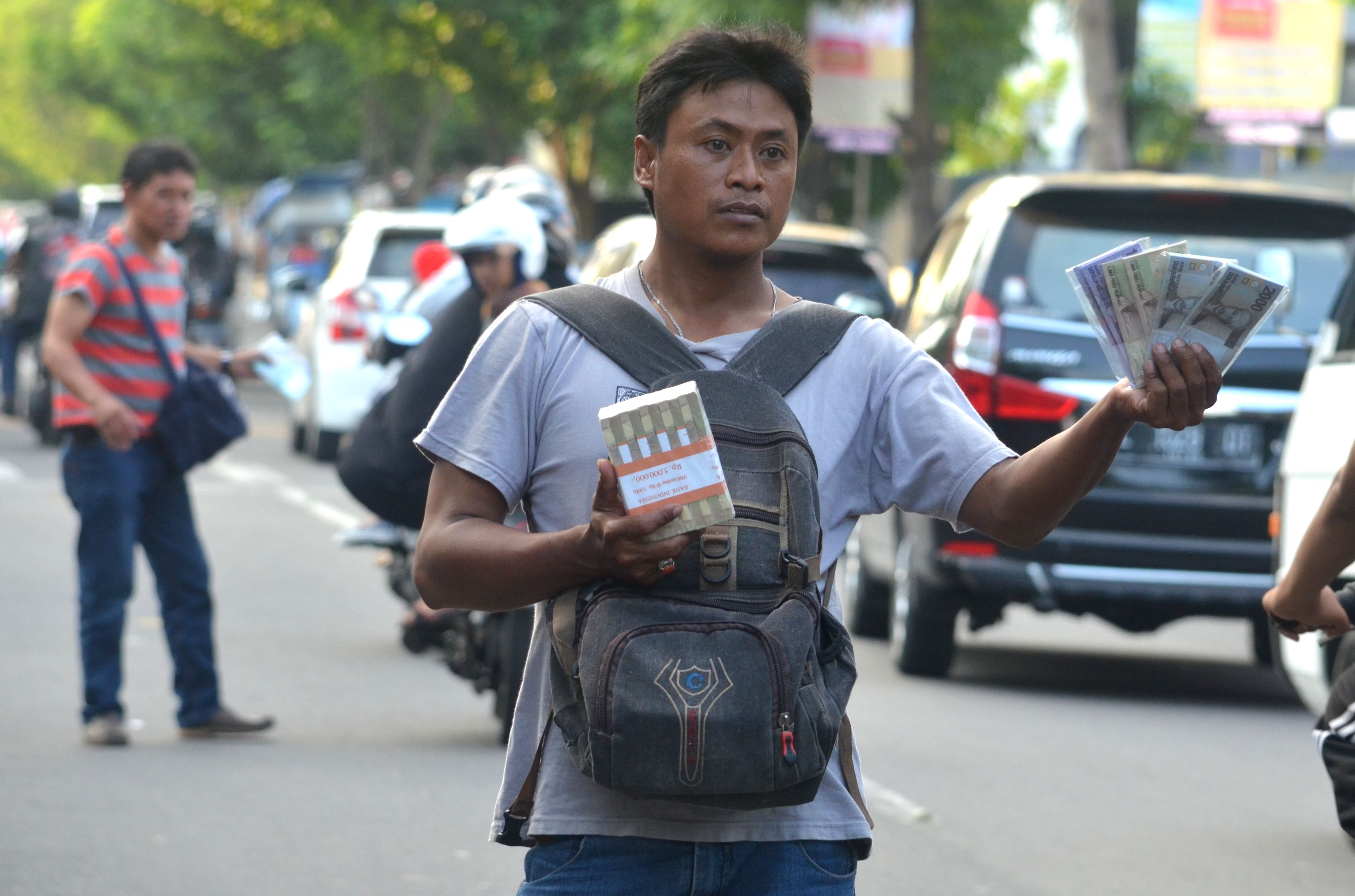  Penjual jasa penukaran uang menawarkan uang baru kepada pengguna jalan di Jalan Soetomo Kota Madiun