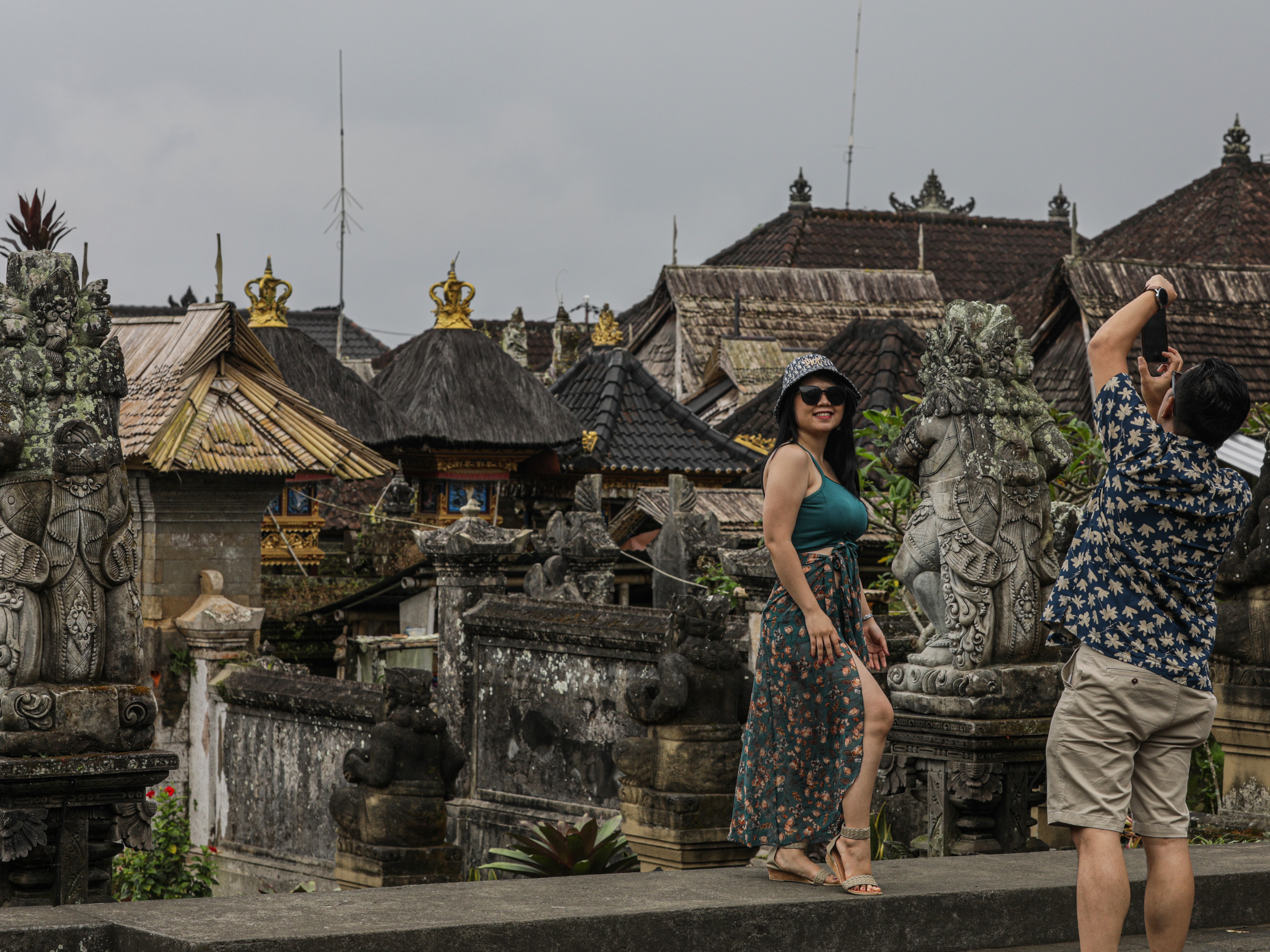 Wisatawan berfoto saat mengunjungi Desa Wisata Penglipuran, Desa Kubu, Bangli, Bali, Jumat (24/3/2023).