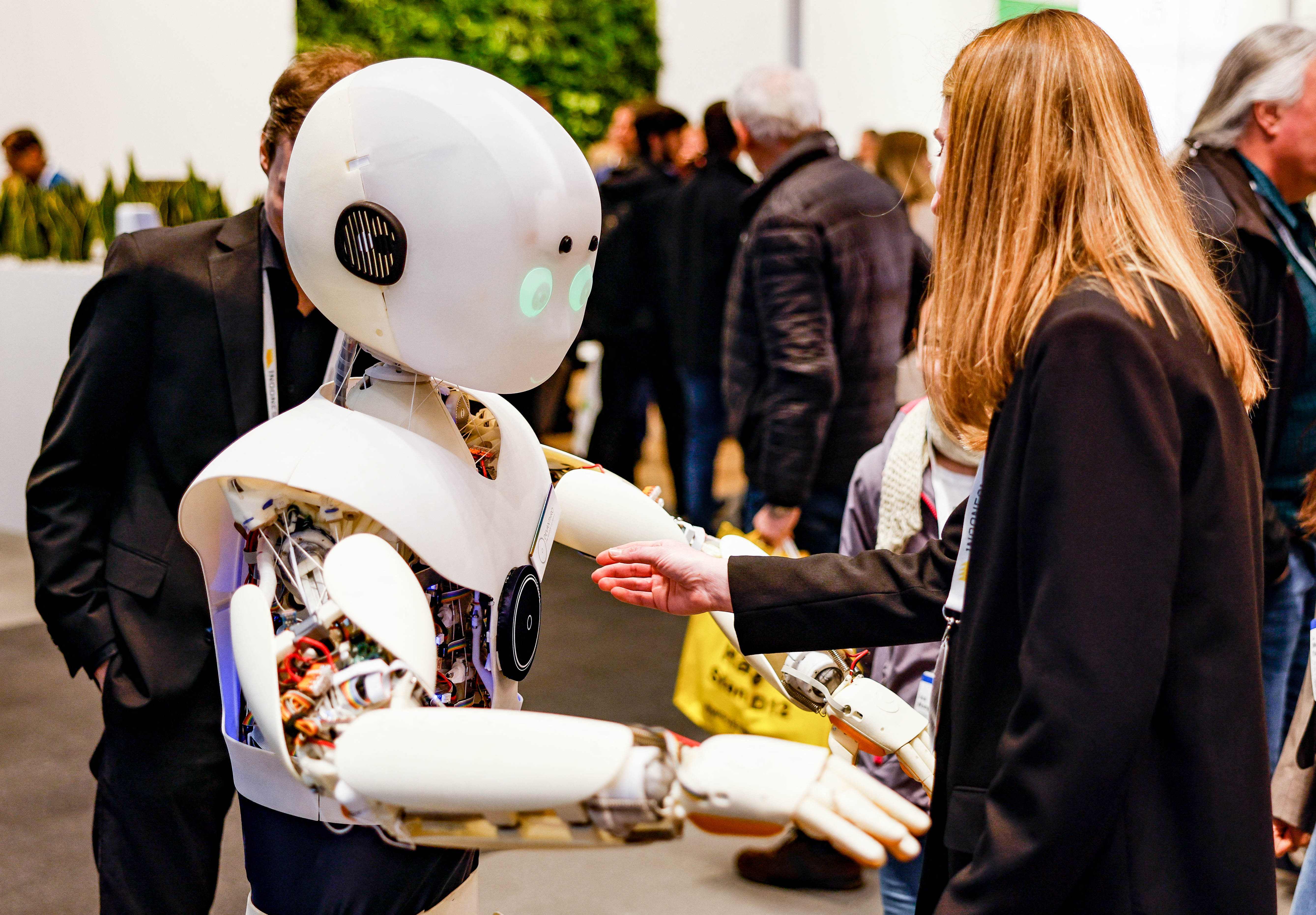 Seorang perempuan berinteraksi dengan sebuah robot di ajang Hannover Messe 2023 di Jerman.