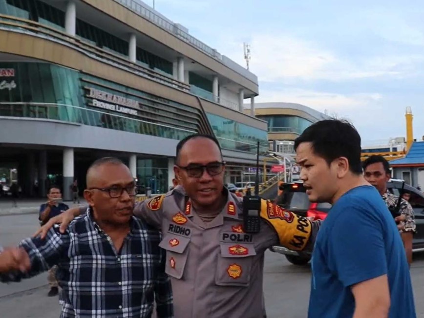 Petugas berusaha menenangkan pemudik yang marah karena ada pejabat menyerobot antrean di Pelabuhan Bakauheni.