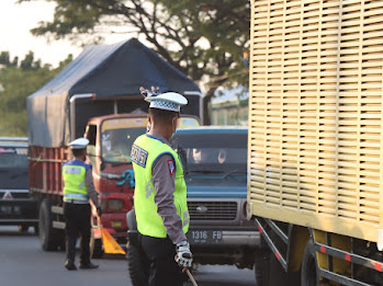Personel Polres Brebes sedang menghentikan truk untuk masuk ke Pangkalan Kecipir di Losari (parbatasan Jateng-Jabar).