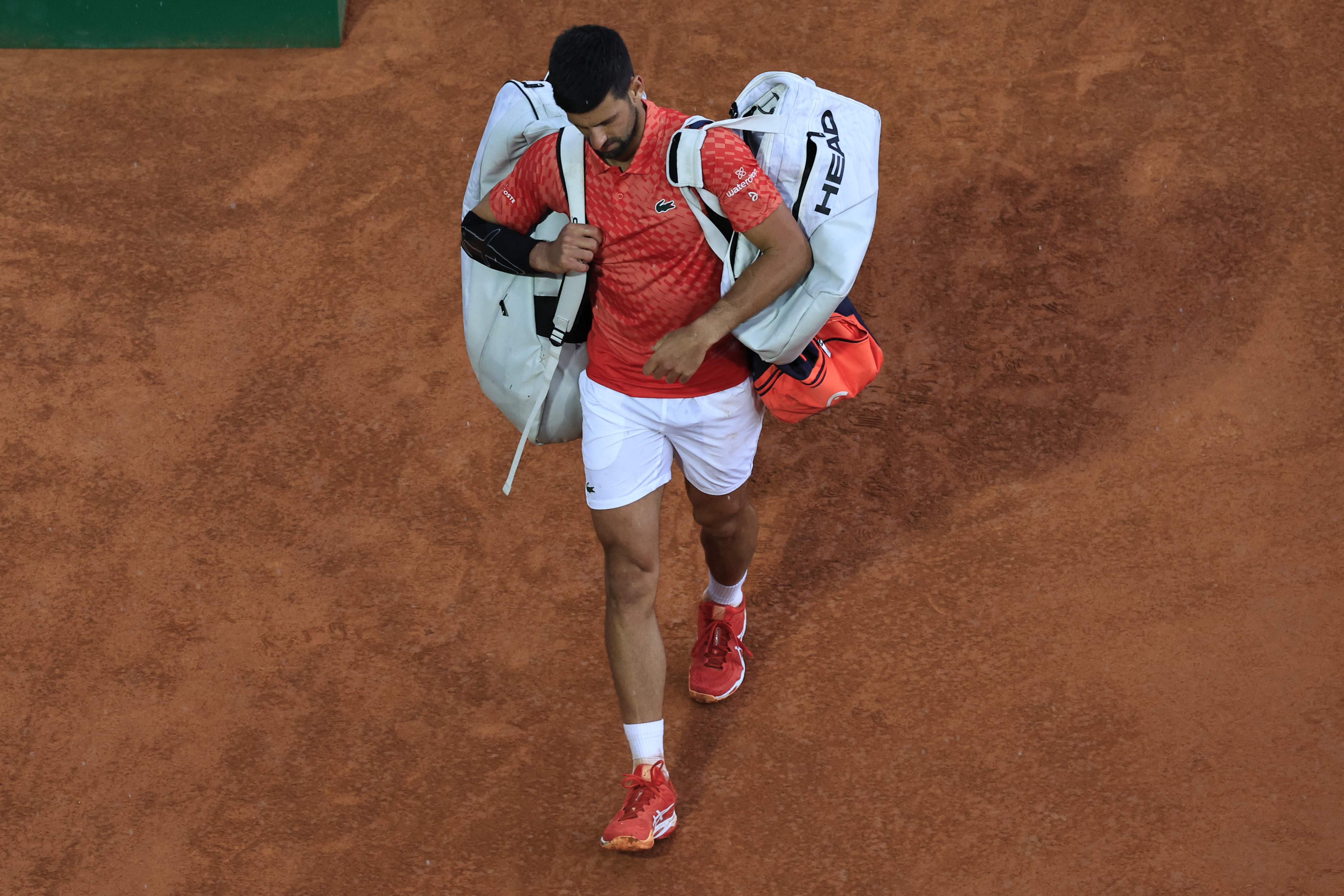 Petenis Serbia Novak Djokovic meninggalkan lapangan usai dikalahkan Lorenzo Musetti di Monte Carlo Masters.
