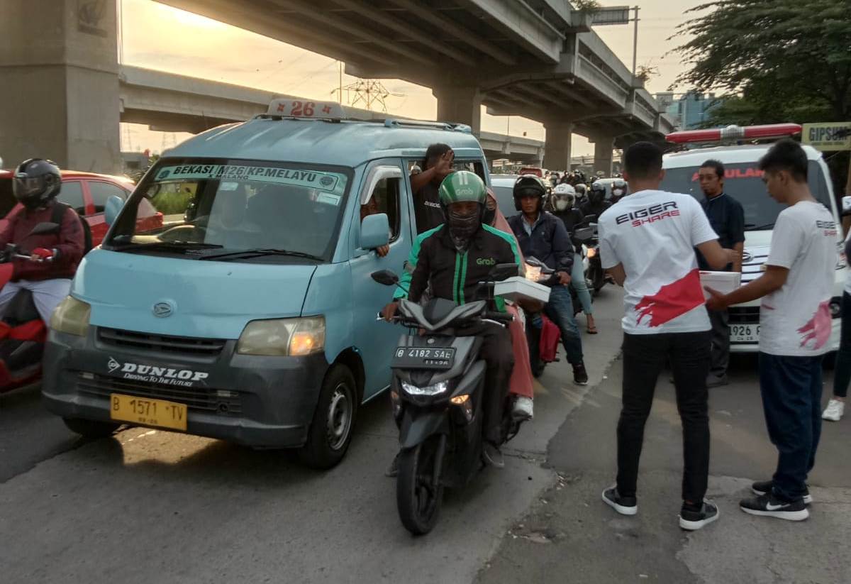 Karyawan Eiger membagikan takjil kepada warga yang melintas di depan toko Eiger yang berada di sejumlah kota di Indonesia.