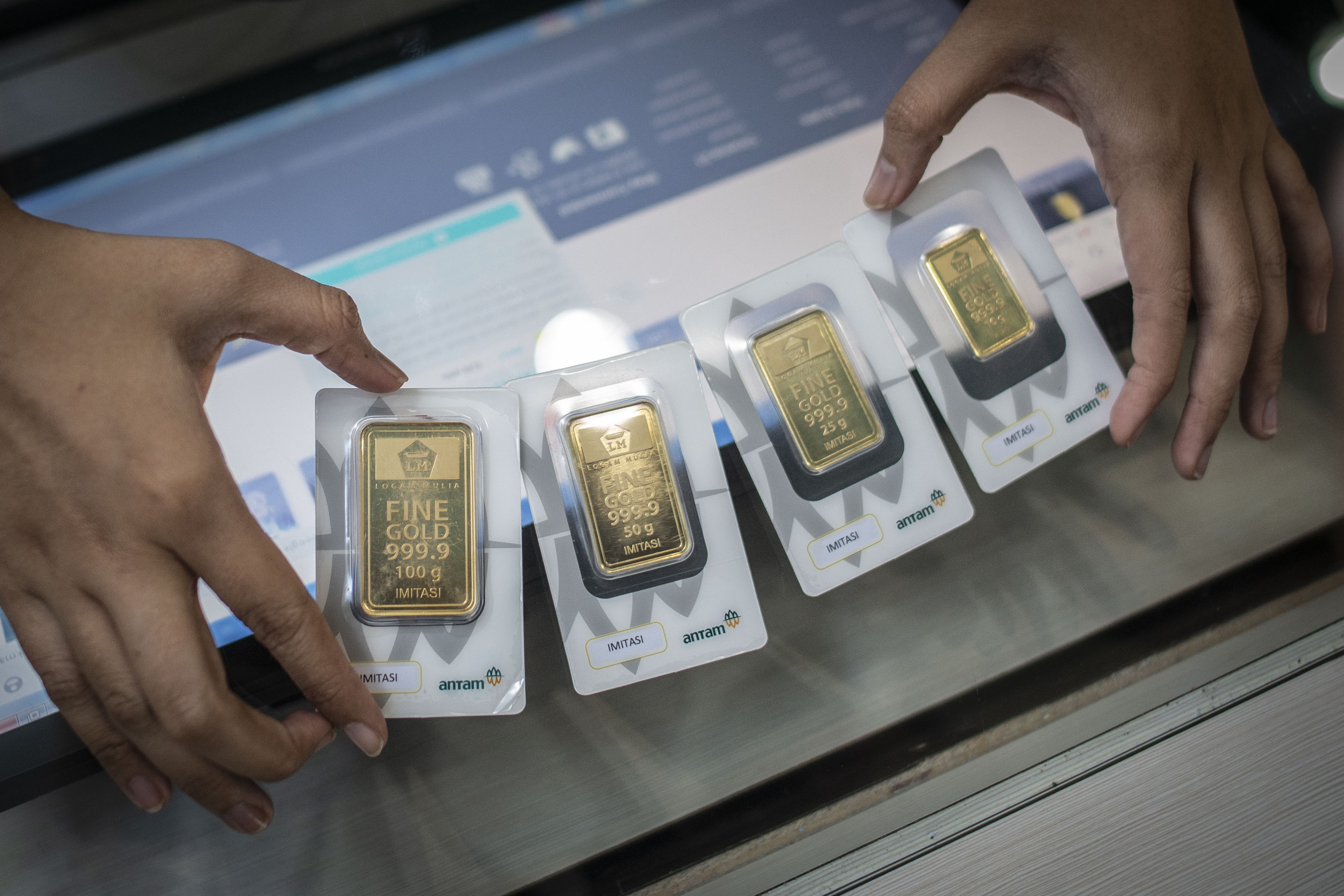  Karyawan menunjukkan imitasi emas batangan Antam di Butik Emas, Jakarta, Selasa (3/3/2020).