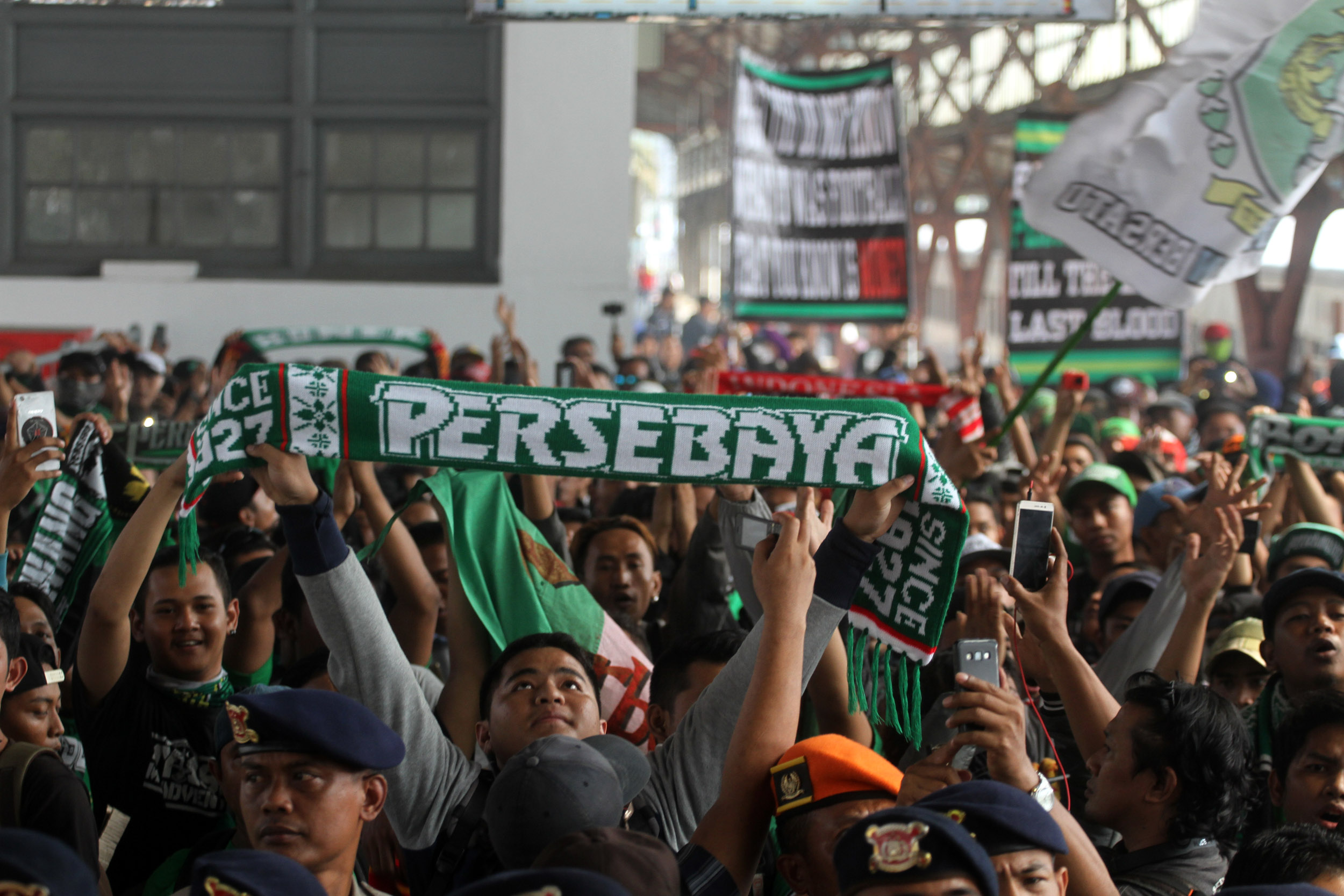 Suporter Persebaya Surabaya menyanyikan yel-yel saat tiba di Stasiun Pasar Senen, Jakarta, Selasa (2/8/2016).