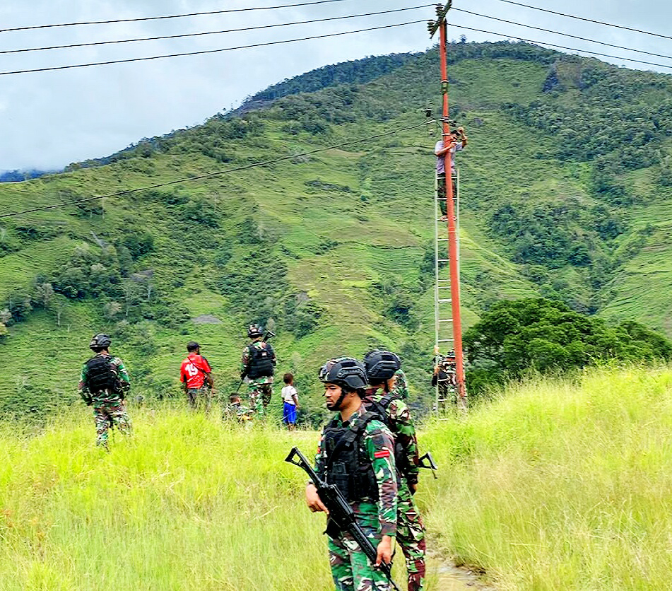 Prajurit TNI berjaga saat pemasangan prasarana publik di Papua
