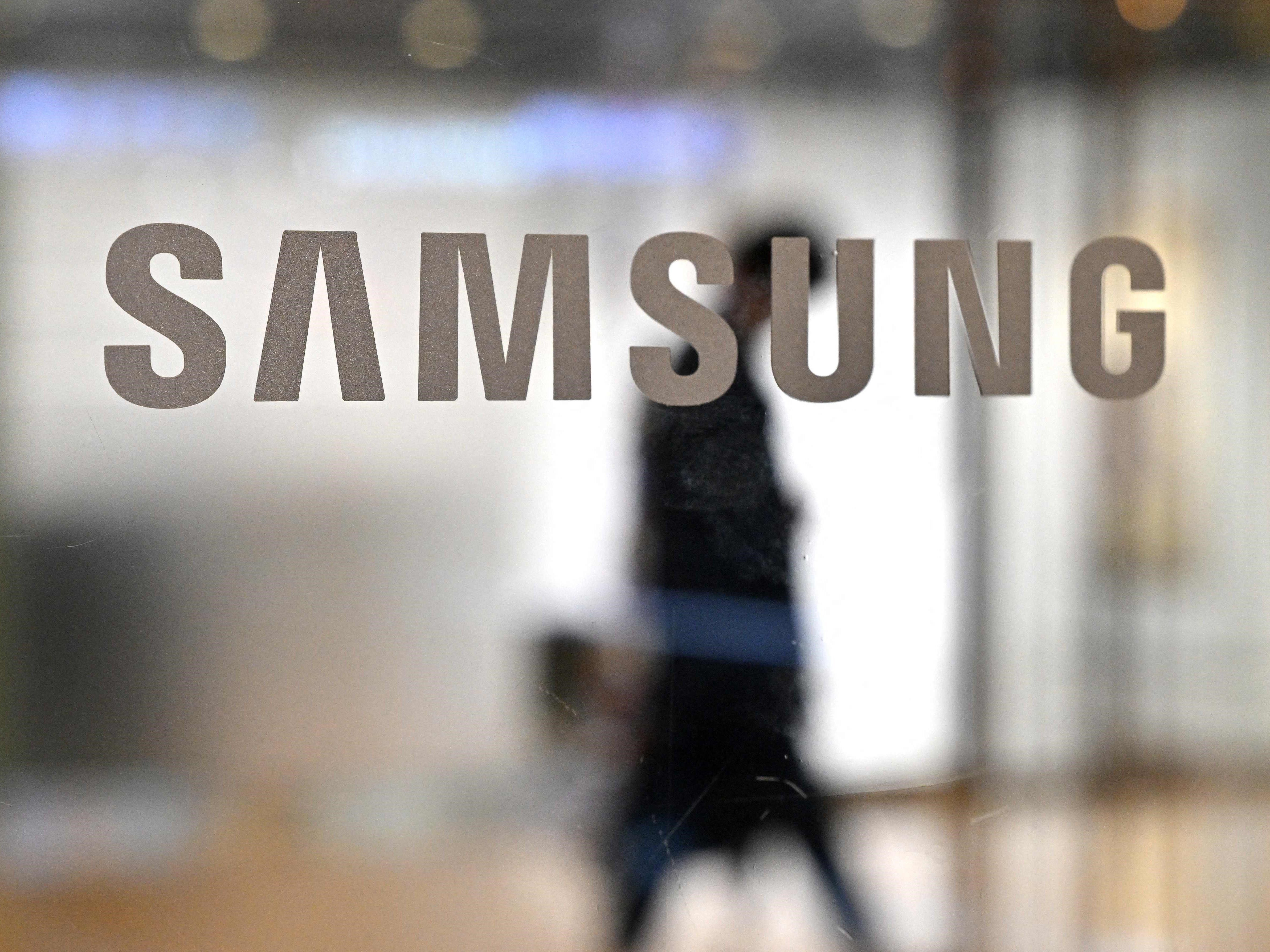 Seorang pria berjalan melewati logo Samsung di pintu kaca di gedung perusahaan Seocho di Seoul pada 7 April 2023.