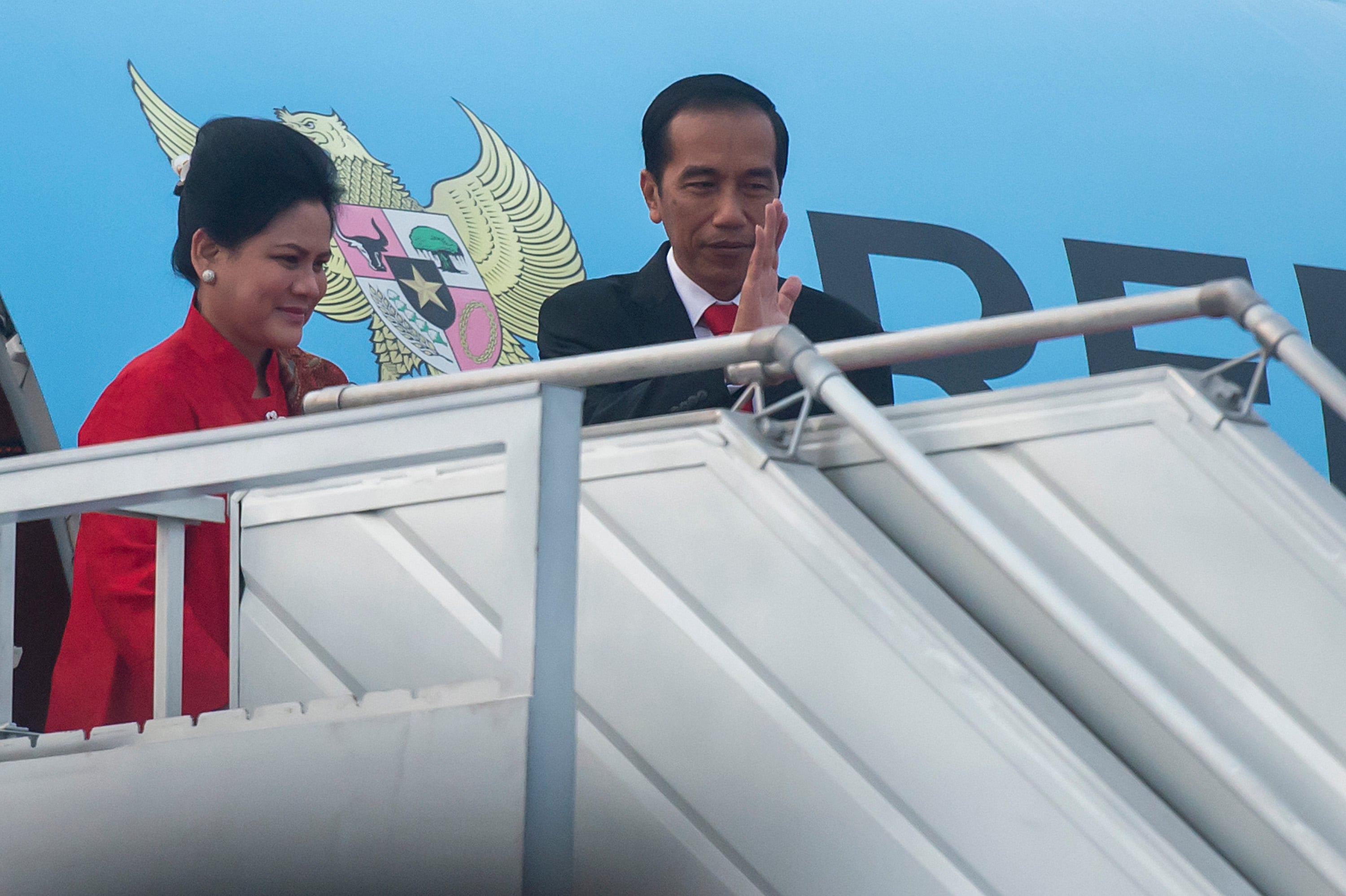Presiden Joko Widodo (kanan) dan Ibu Negara Iriana Joko Widodo (kiri) melambaikan tangan sebelum masuk ke pesawat kepresidenan