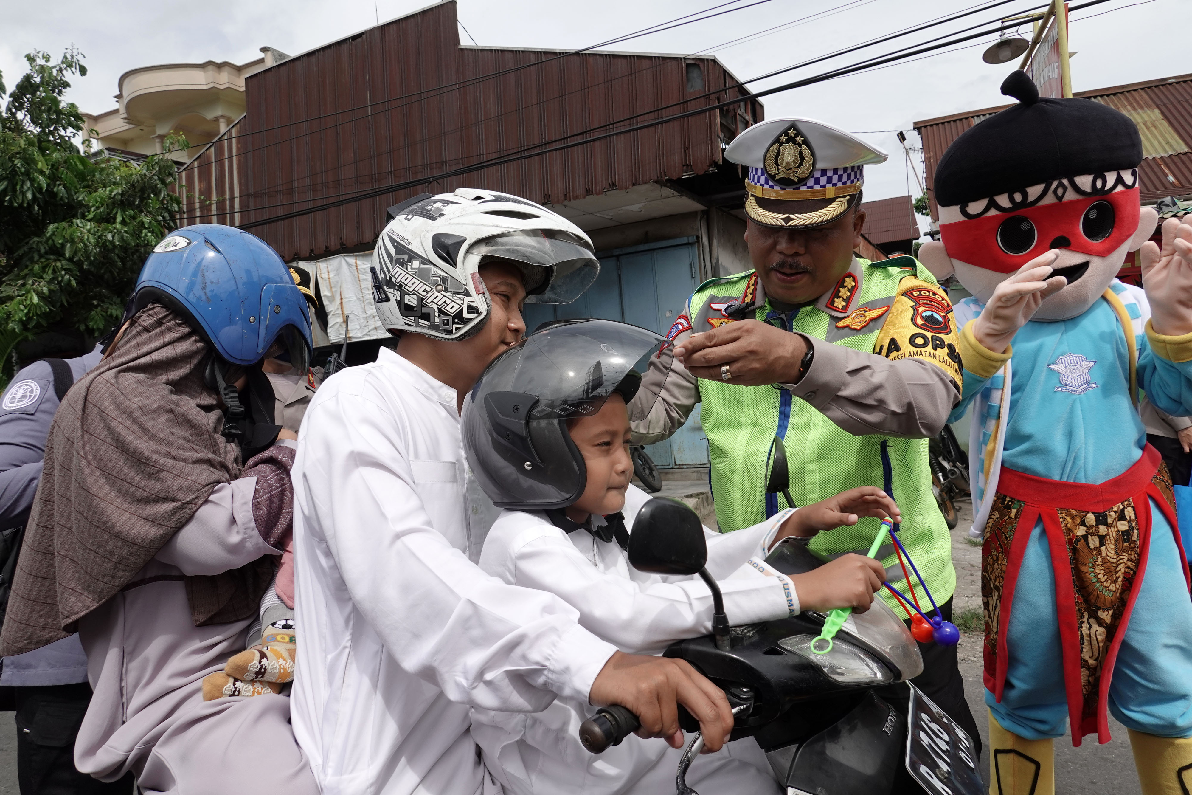 Seorang polisi mengenakan helm pelindung pada seorang anak di Banyumas, Jawa Tengah.