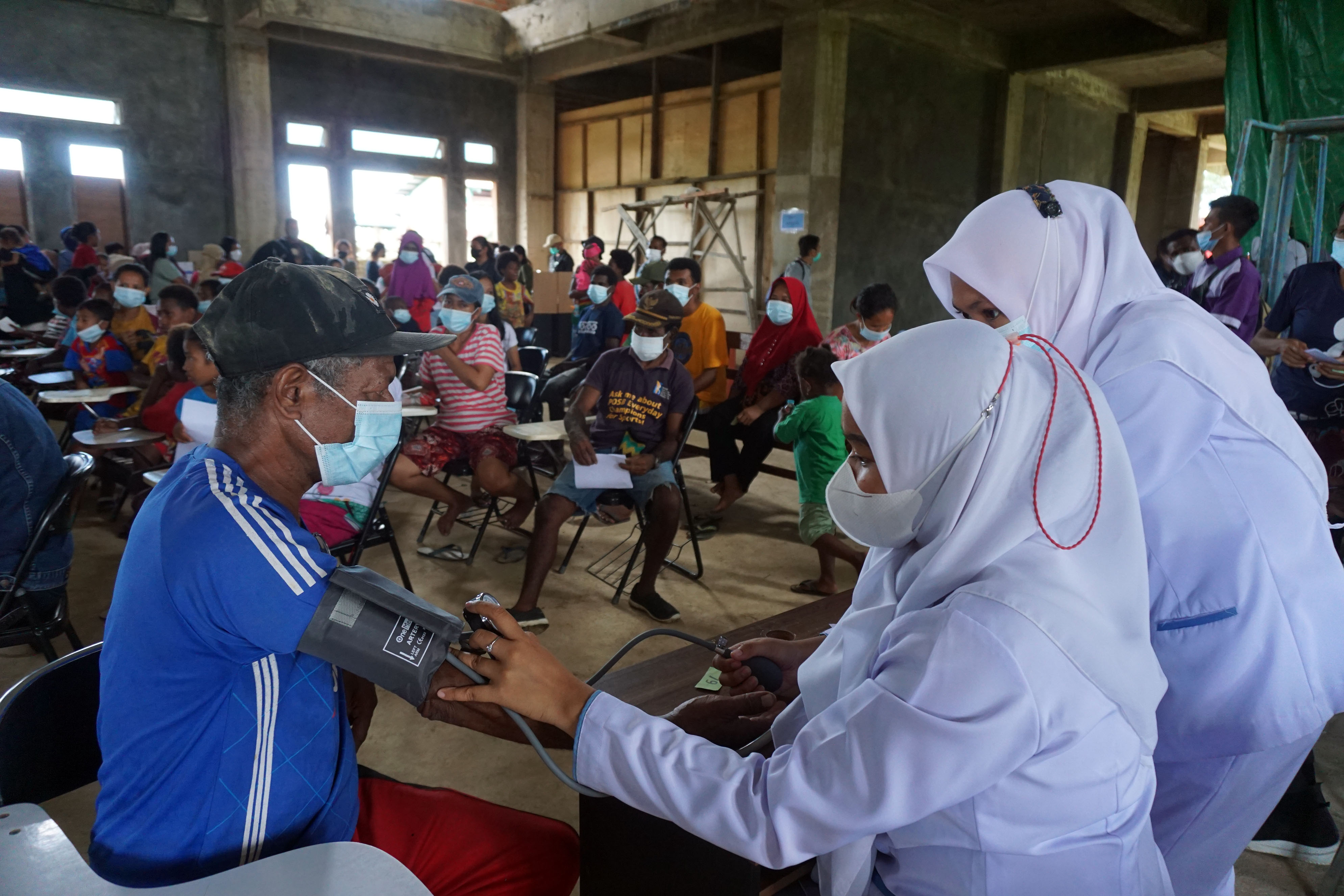 Petugas medis memeriksa tekanan darah warga pada acara pengobatan massal gratis di Kampus STIKES Papua, Papua Barat, Sabtu (27/8/2022).