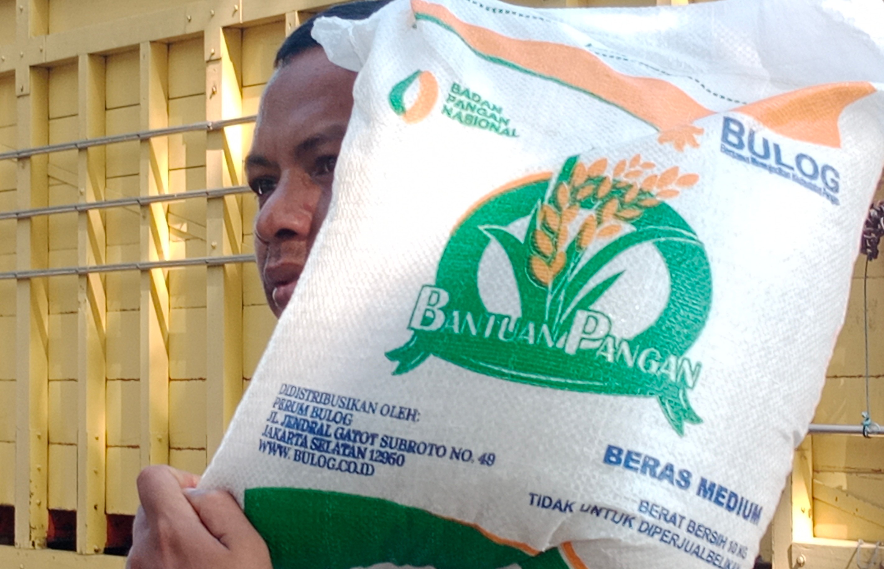 Warga membawa beras bantuan dari pemerintah