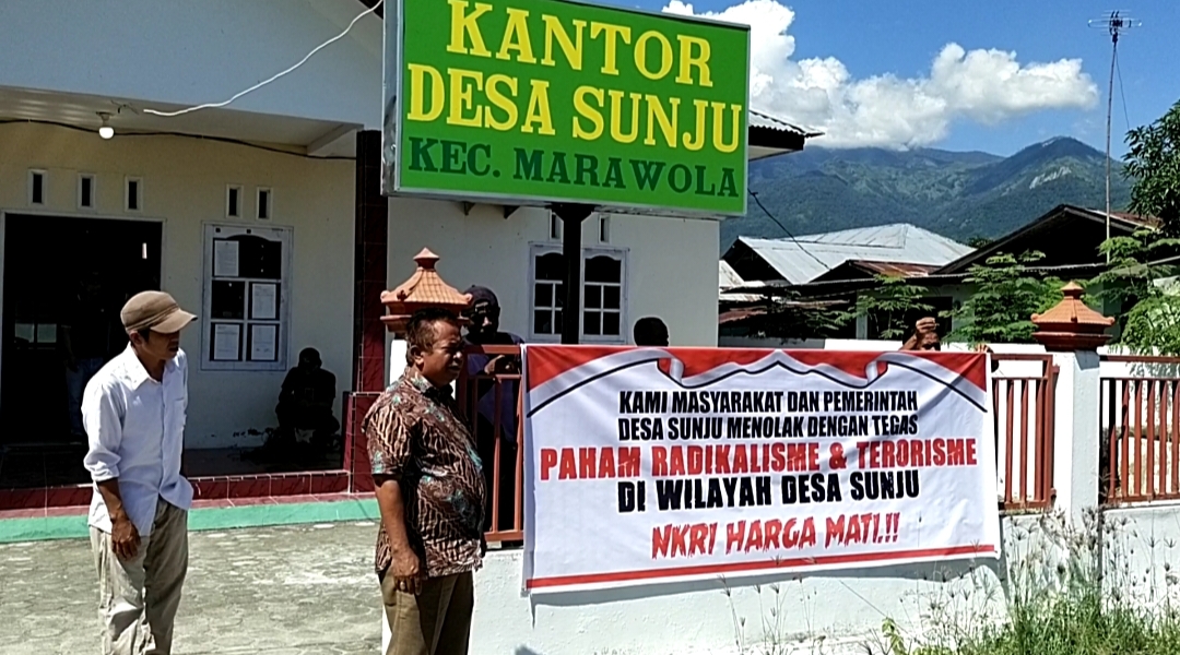 Spanduk penolakan terhadap terorisme dan radikalisme terlihat di kantor Desa Sunju, Sulawesi Tengah.