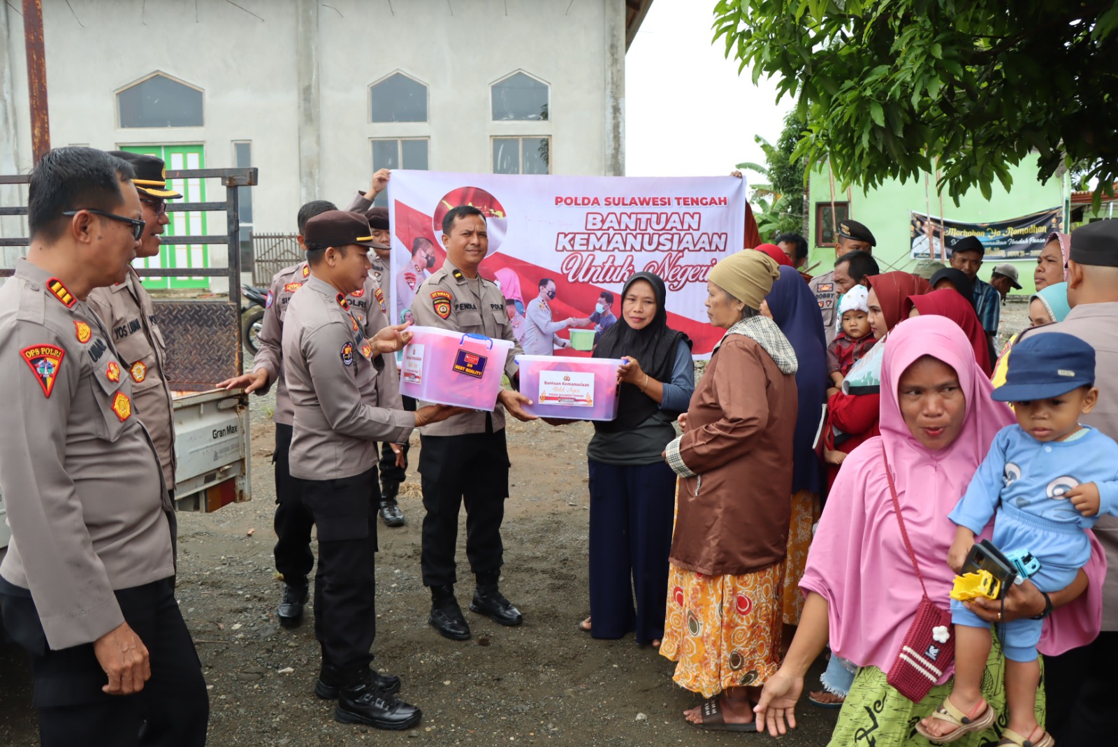 Personel Polda Sulteng membagikan sembako ke warga dalam Baksos Ramadan.