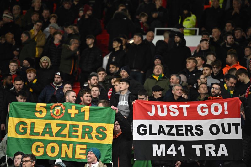 Para pendukung Manchester United membentangkan poster Glazers Out.