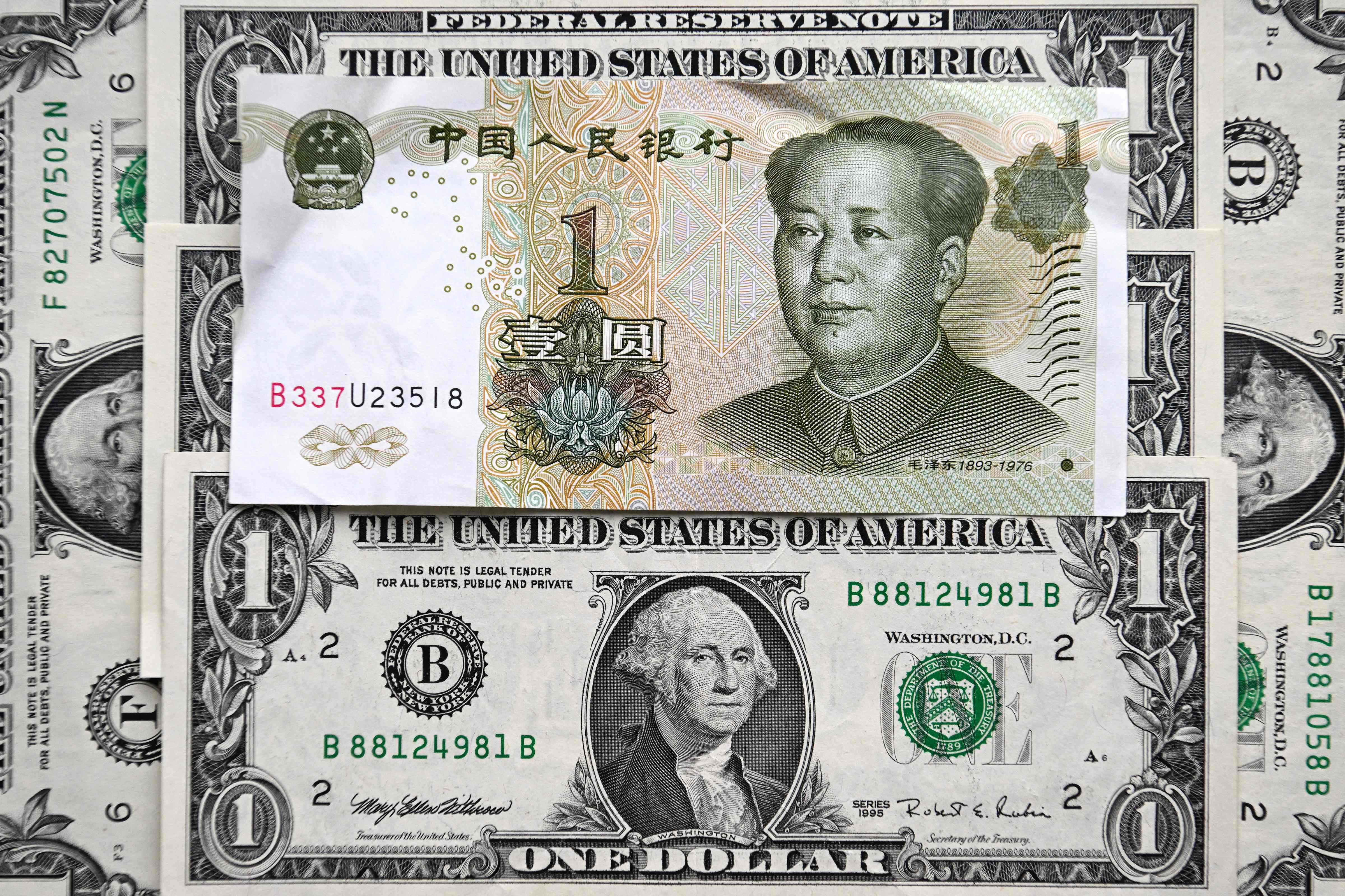 Uang kertas Yuan Tiongkok dan dolar Amerika Serikat.