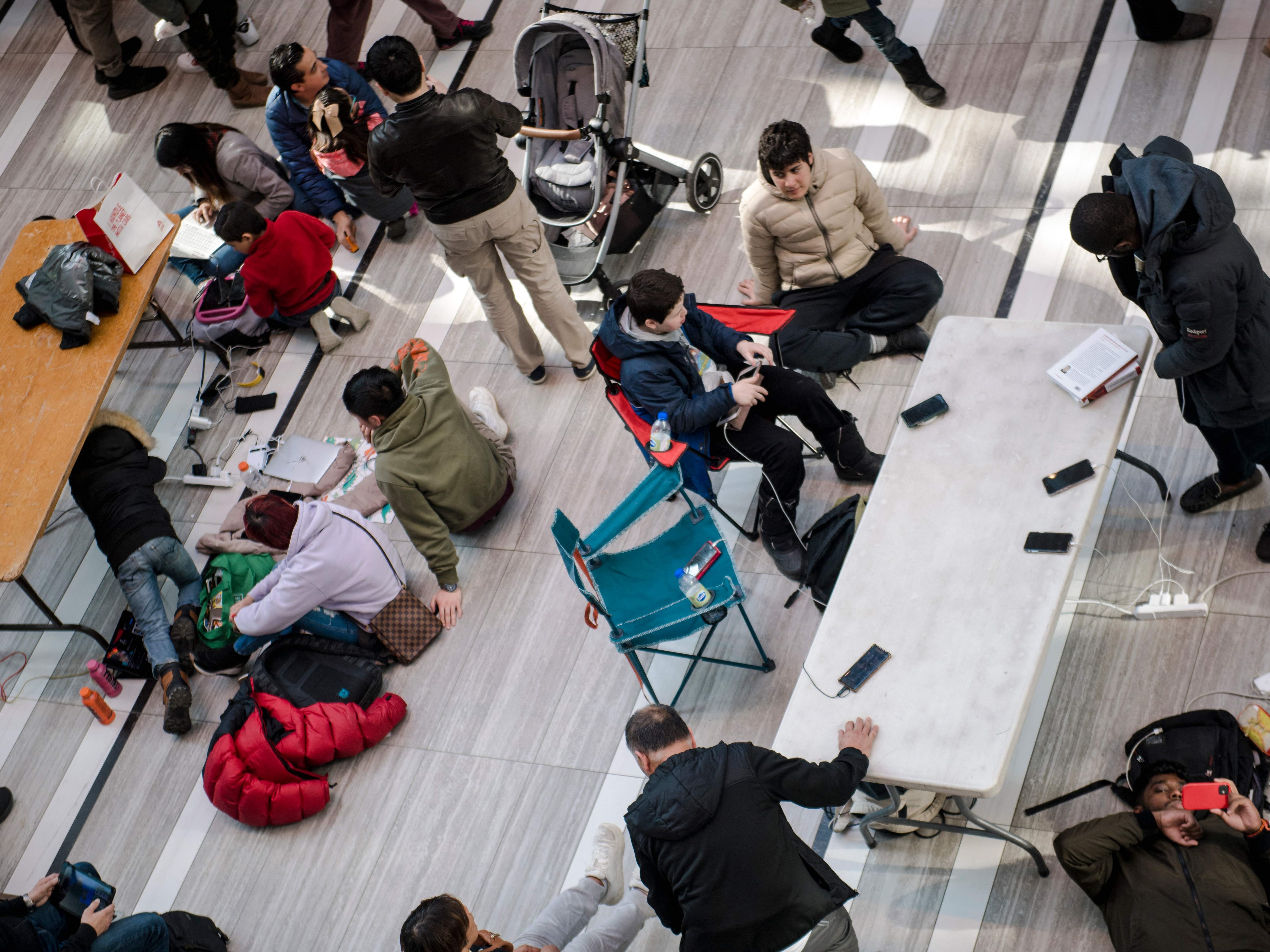 Orang-orang mengisi daya ponsel mereka di stasiun yang dipasang di CF Fairview Mall pada 07 April 2023, di Montreal, Kanada.