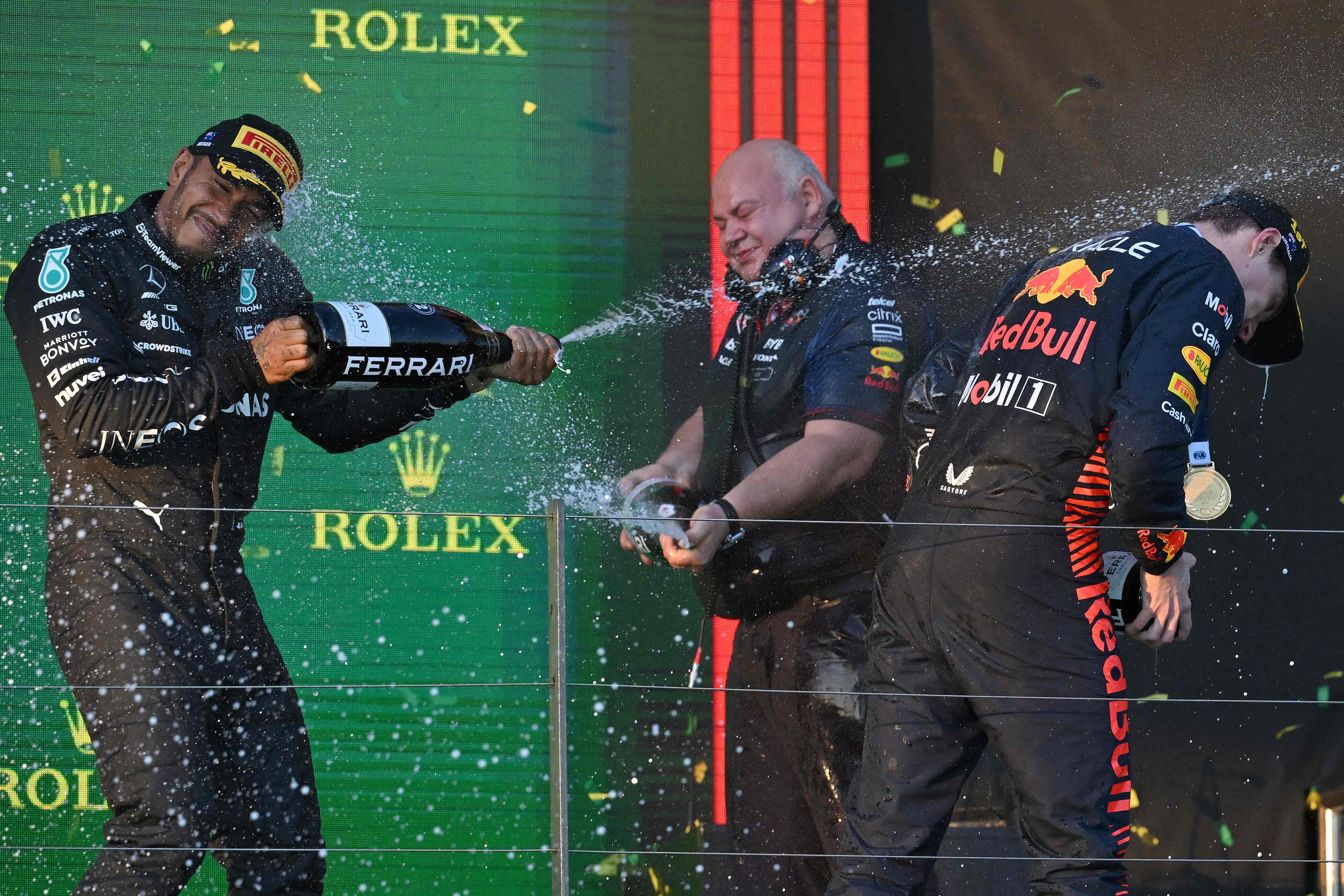 Pembalap Mercedes Lewis Hamilton menyemprotkan sampanye ke pembalap Red Bull Max Verstappen di podium GP Australia.