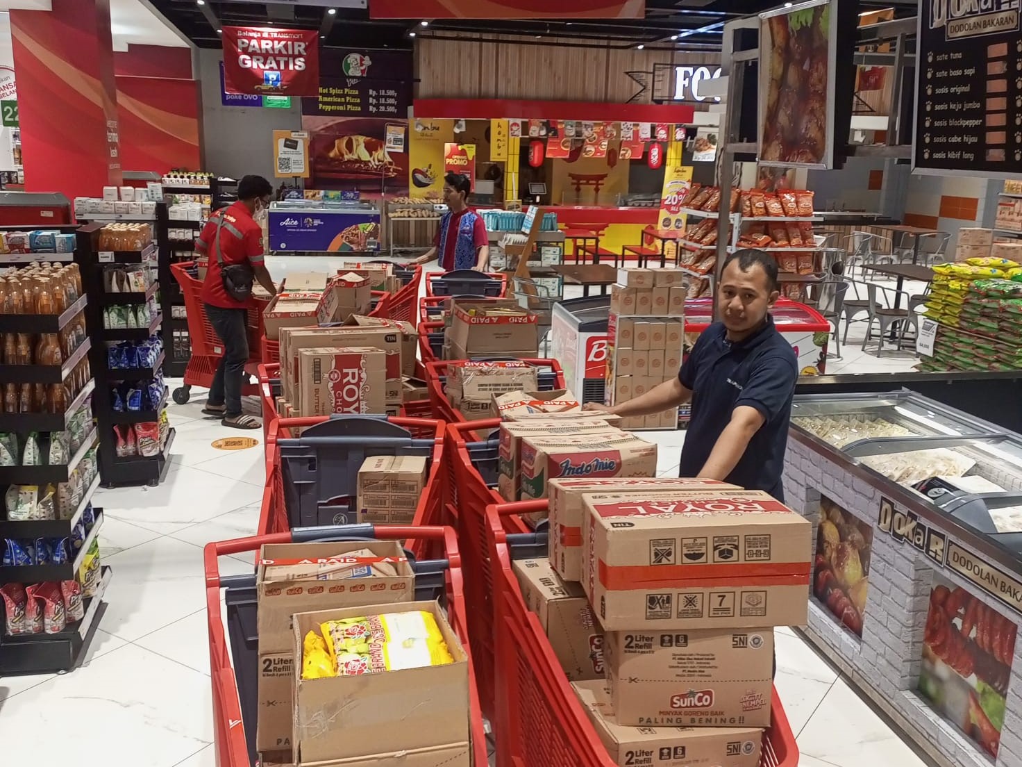 Pelanggan memborong sejumlah barang kebutuhan pada Transmart Ramadan Midnight Sale, Sabtu (1/4).